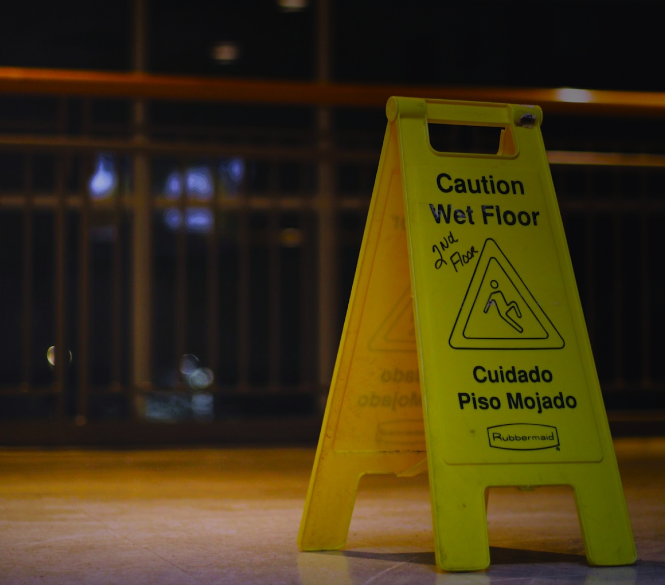 Woman holding her neck while looking at her phone near a car accident.