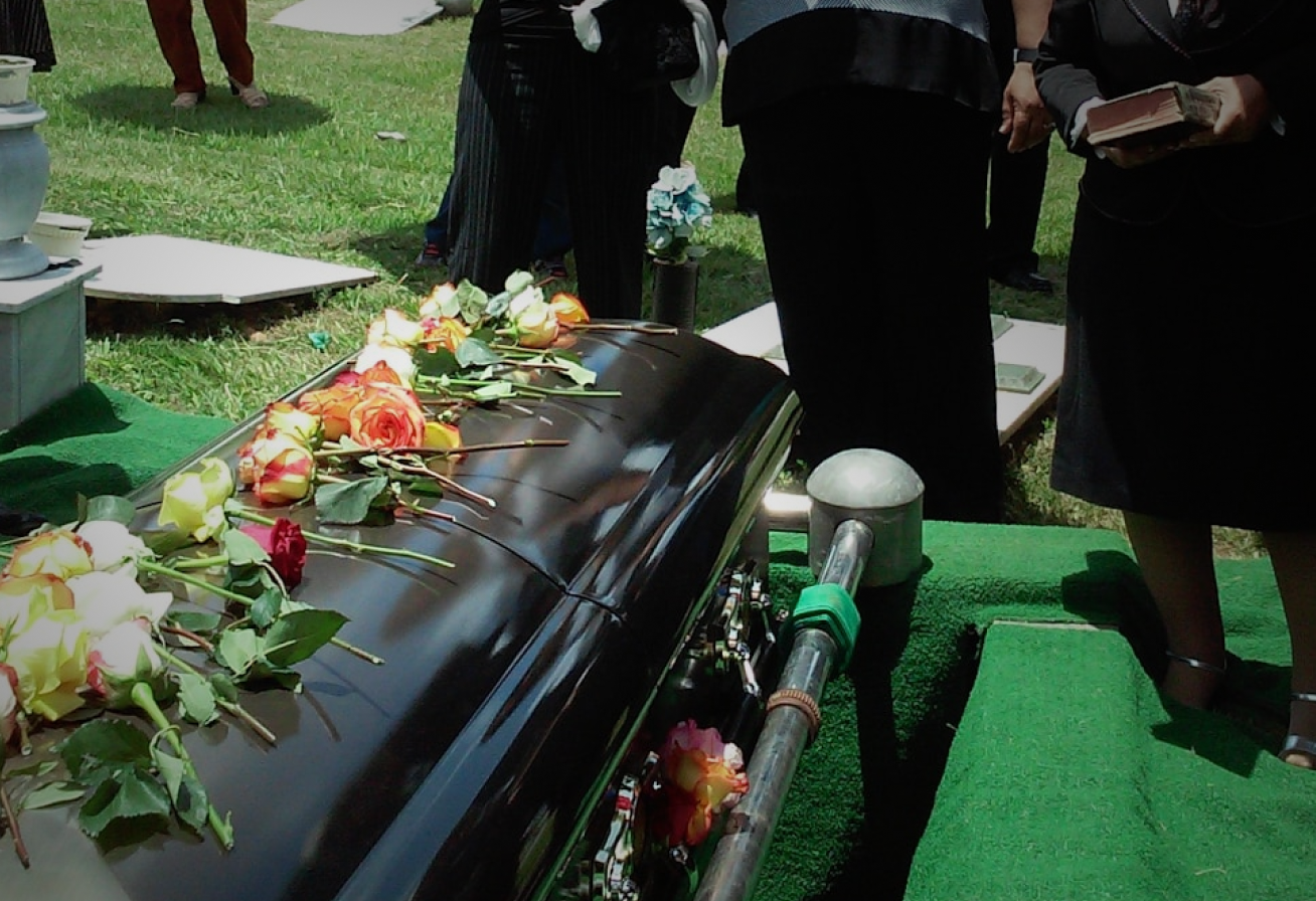 Woman holding her neck while looking at her phone near a car accident.