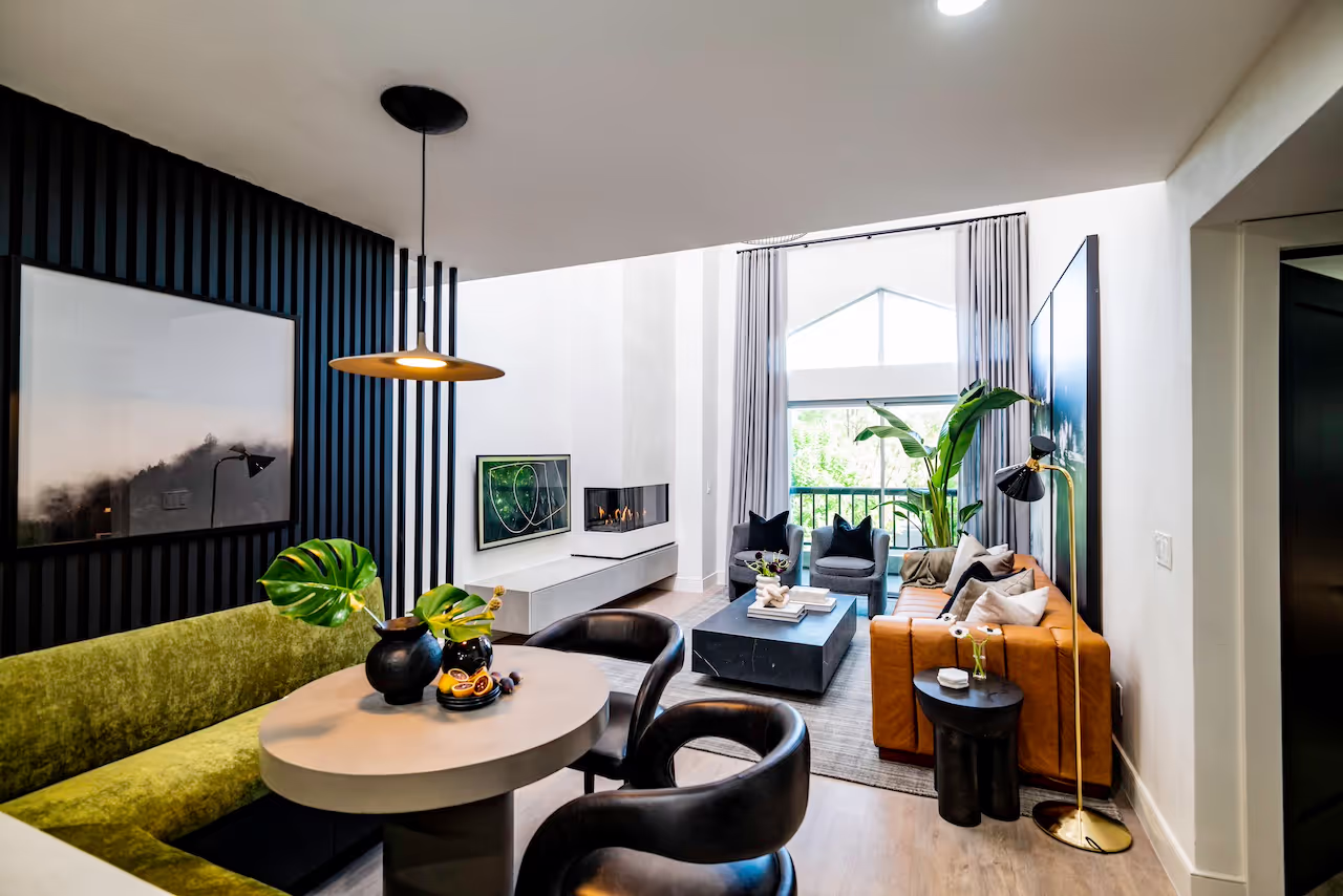 Contemporary dining and kitchen space with custom black cabinetry, velvet banquette seating, and modern pendant lighting from Howie Mandel’s Celebrity IOU renovation. Cabinetry by Marvel Cabinetry for HGTV’s Property Brothers: Celebrity IOU  Howie Mandel