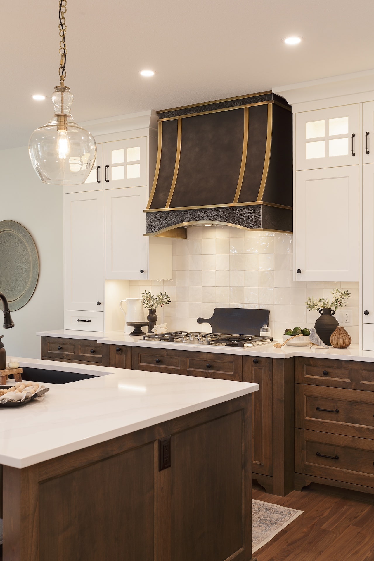 Custom kitchen featuring rich wood cabinetry, detailed millwork, brass accents, and a large central island. Cabinetry by Marvel Cabinetry.