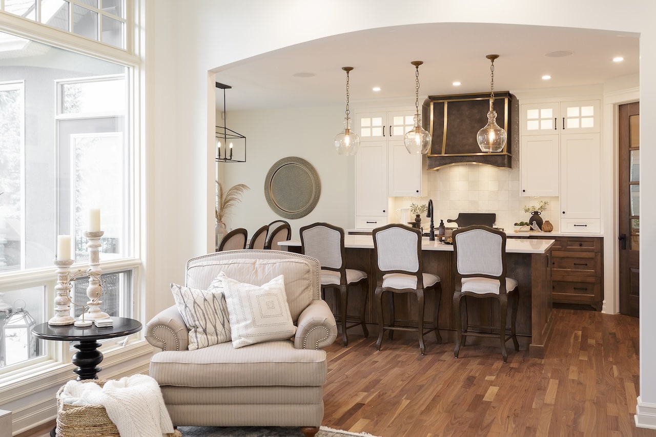 Dining area connected to custom kitchen with wood flooring, artisan cabinetry, and matching decorative hood. Cabinetry by Marvel Cabinetry.