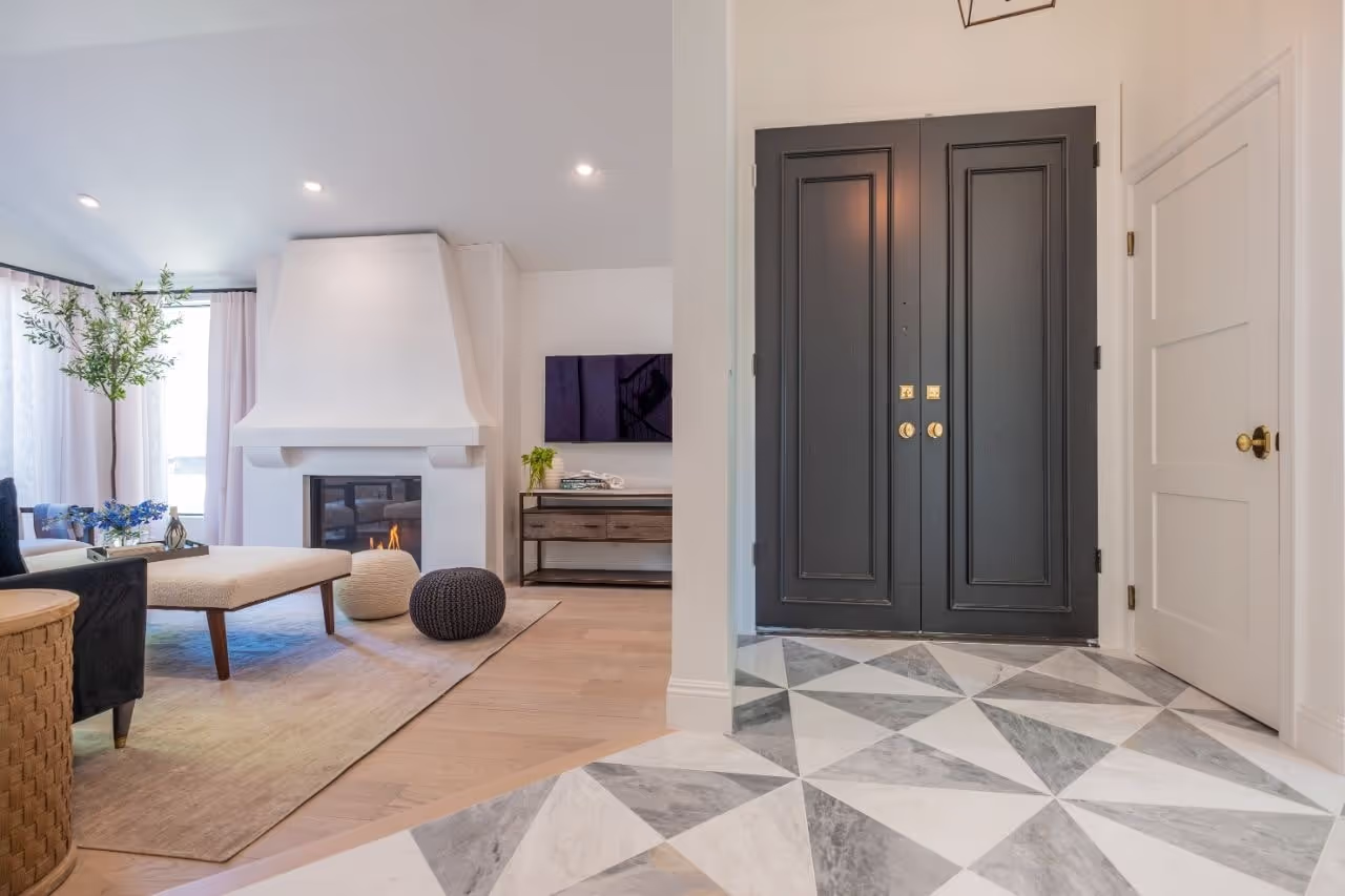 Living room with custom fireplace cabinetry, geometric tile flooring, and modern styling from Jeremy Renner’s Celebrity IOU remodel. Cabinetry by Marvel Cabinetry for HGTV’s Property Brothers: Celebrity IOU - Jeremy Renner
