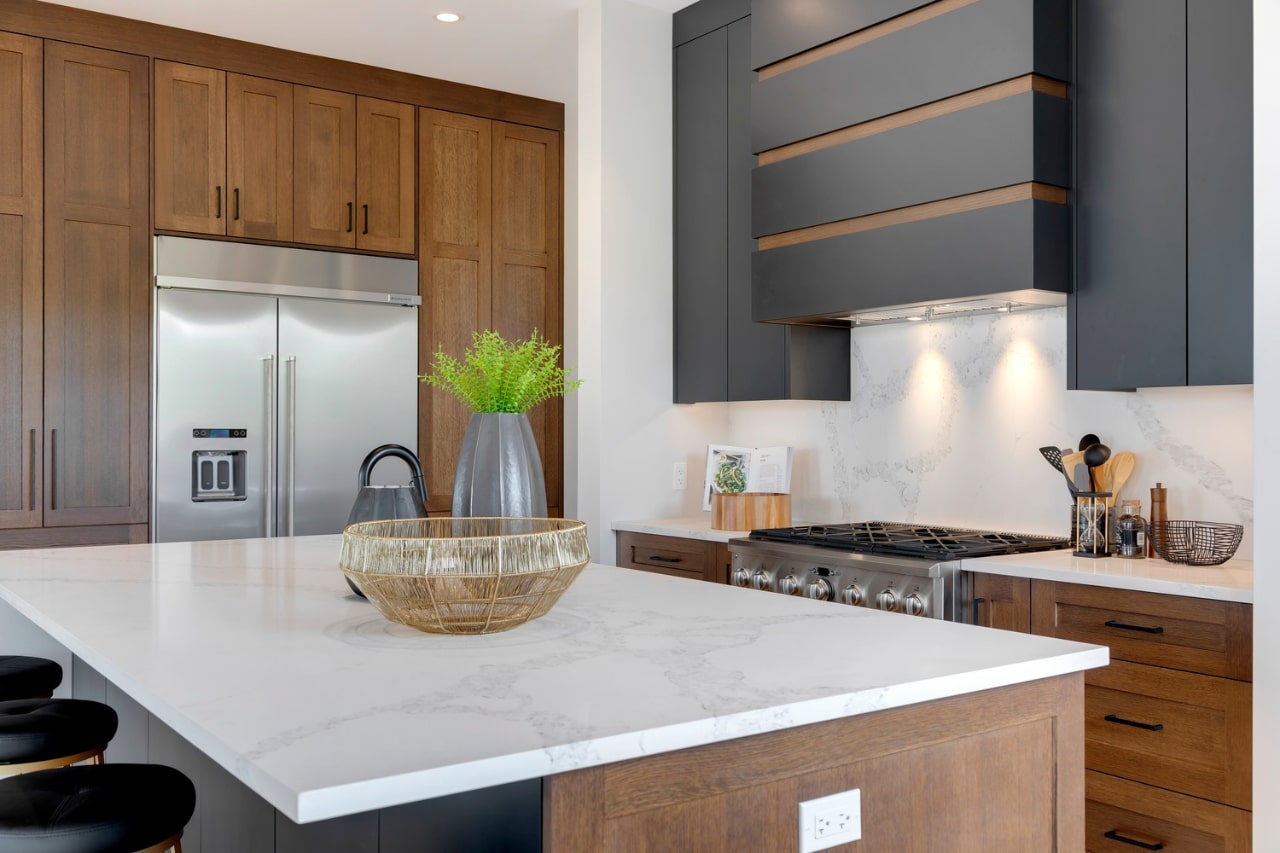 Kitchen showcasing custom wood cabinetry, quartz counters, and open shelving paired with dark upper cabinets. Cabinetry by Marvel Cabinetry.
