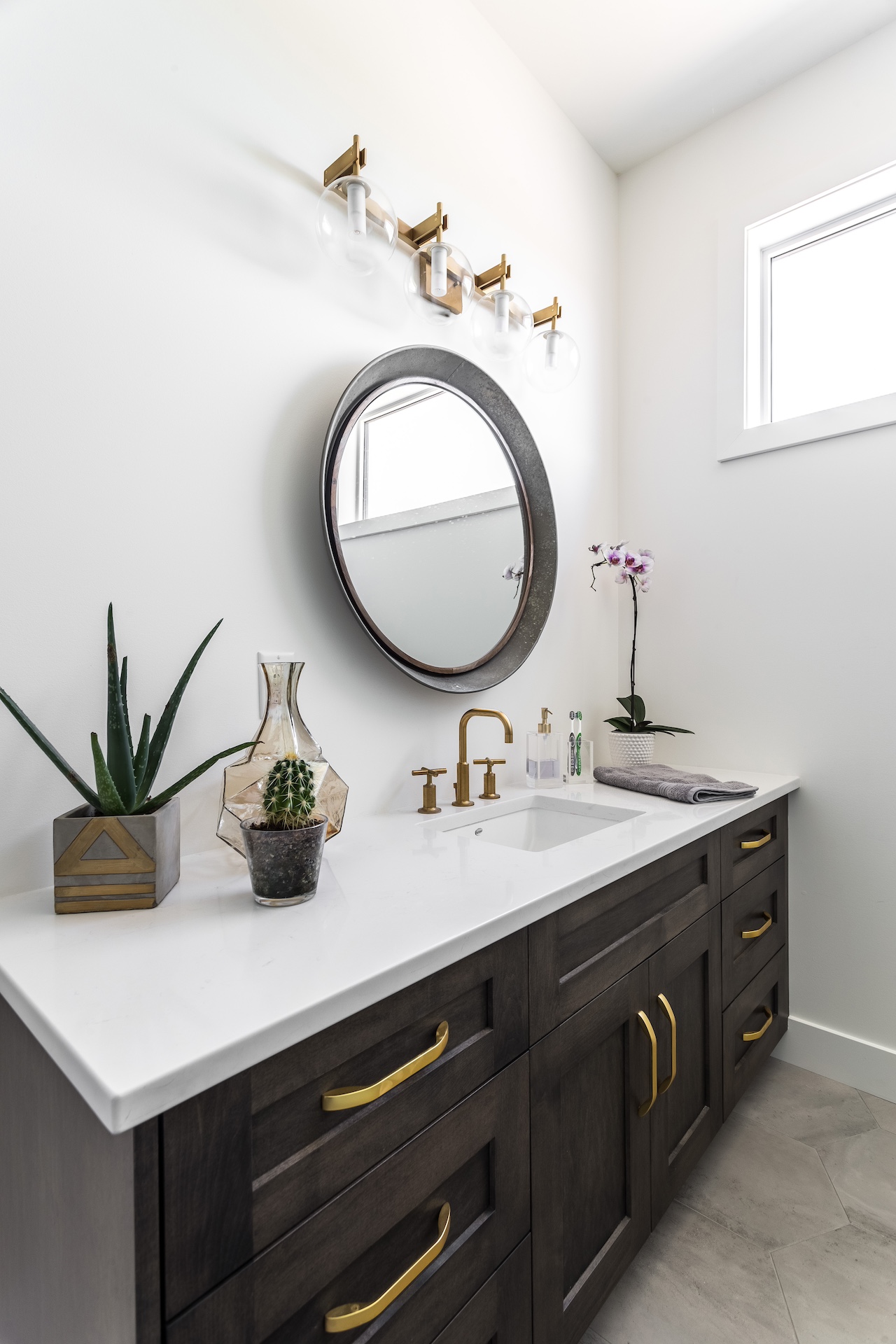Bathroom with custom dark double vanity cabinetry, brass hardware, and clean minimalist detailing. Cabinetry by Marvel Cabinetry.