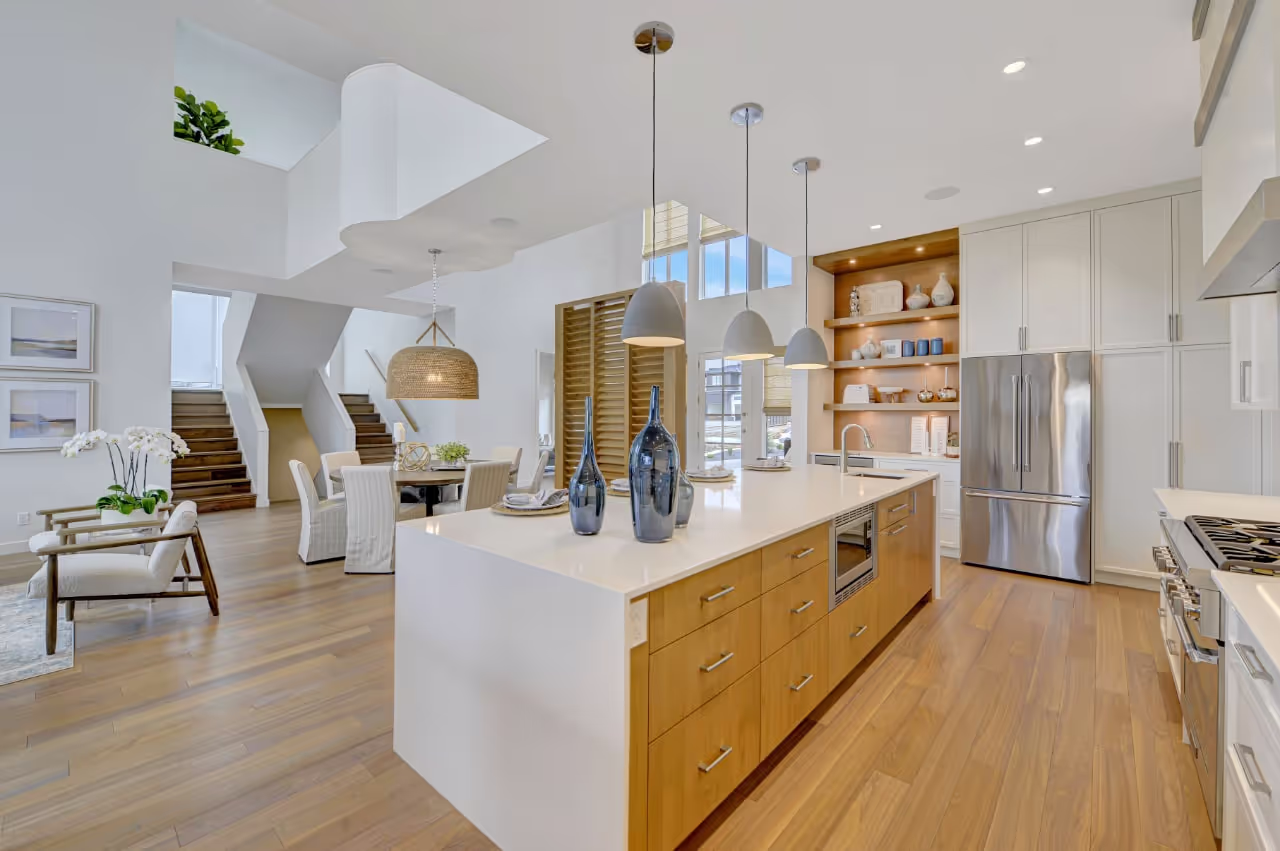 Open-concept kitchen and dining area with custom wood island, white cabinetry, and modern millwork details. Cabinetry by Marvel Cabinetry.