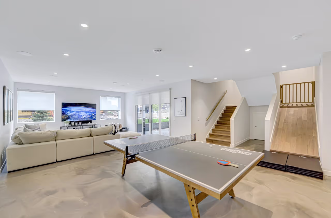 Entertainment basement featuring custom bar cabinetry, lounge seating, and modern built-in millwork. Cabinetry by Marvel Cabinetry.