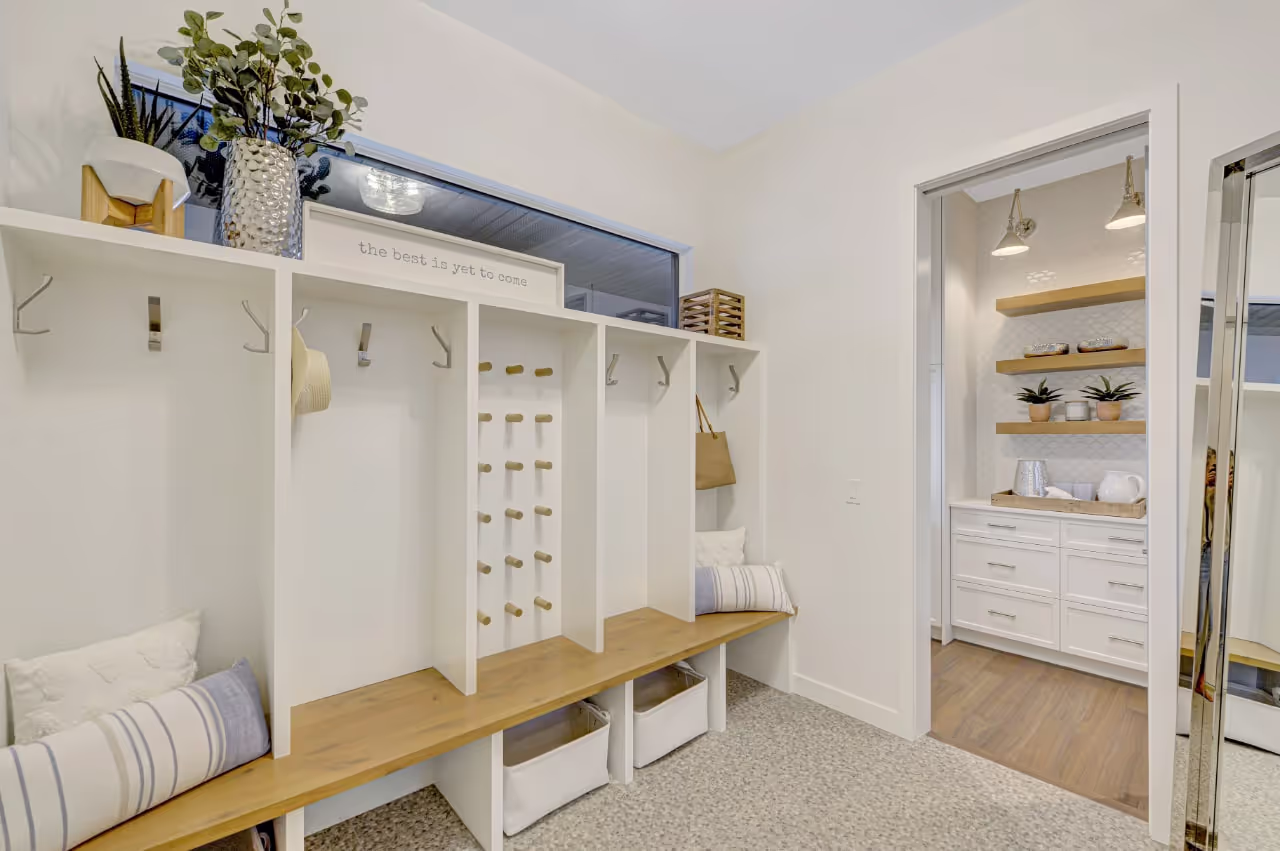 Built-in mudroom storage with custom bench seating, upper cabinets, and organized shelving. Cabinetry by Marvel Cabinetry.