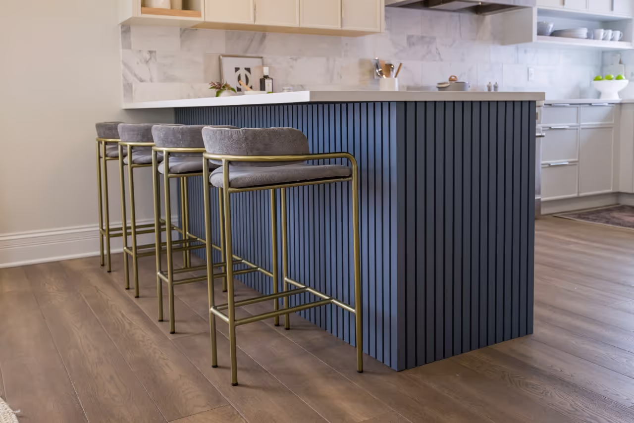 Deep blue fluted kitchen island with brass barstools and custom cabinetry crafted for Viola Davis’ Property Brothers Celebrity IOU transformation. Cabinetry by Marvel Cabinetry for HGTV’s Property Brothers: Celebrity IOU - Viola Davis