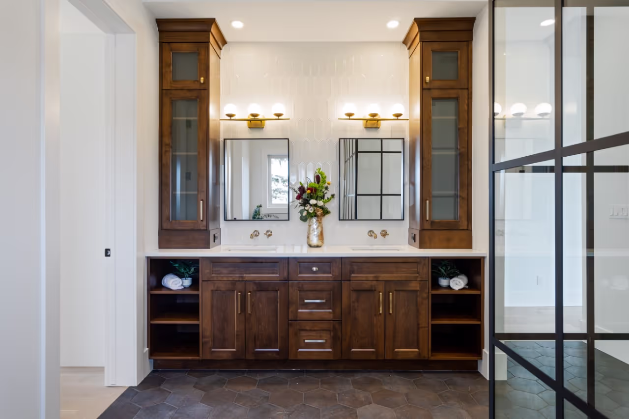 Custom wood office cabinetry with integrated lighting, shelving, and glass-front doors for an elevated workspace. Cabinetry by Marvel Cabinetry.
