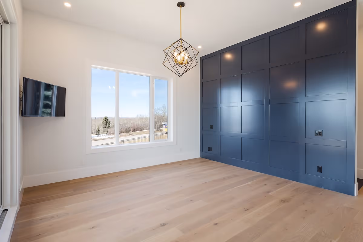Bedroom or multipurpose room showcasing full-height navy cabinetry with minimalist modern millwork. Cabinetry by Marvel Cabinetry.