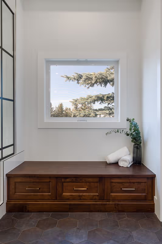 Entryway with custom wood storage cabinet, clean millwork lines, and natural-light framing. Cabinetry by Marvel Cabinetry.