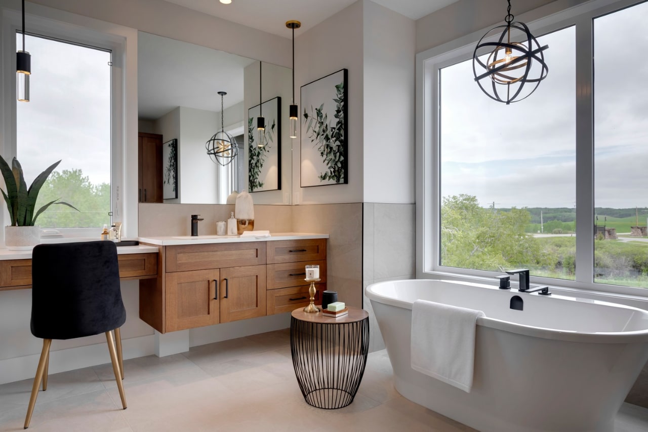 Luxury bathroom with custom floating vanity cabinetry, freestanding tub, and large windows offering natural light. Cabinetry by Marvel Cabinetry.