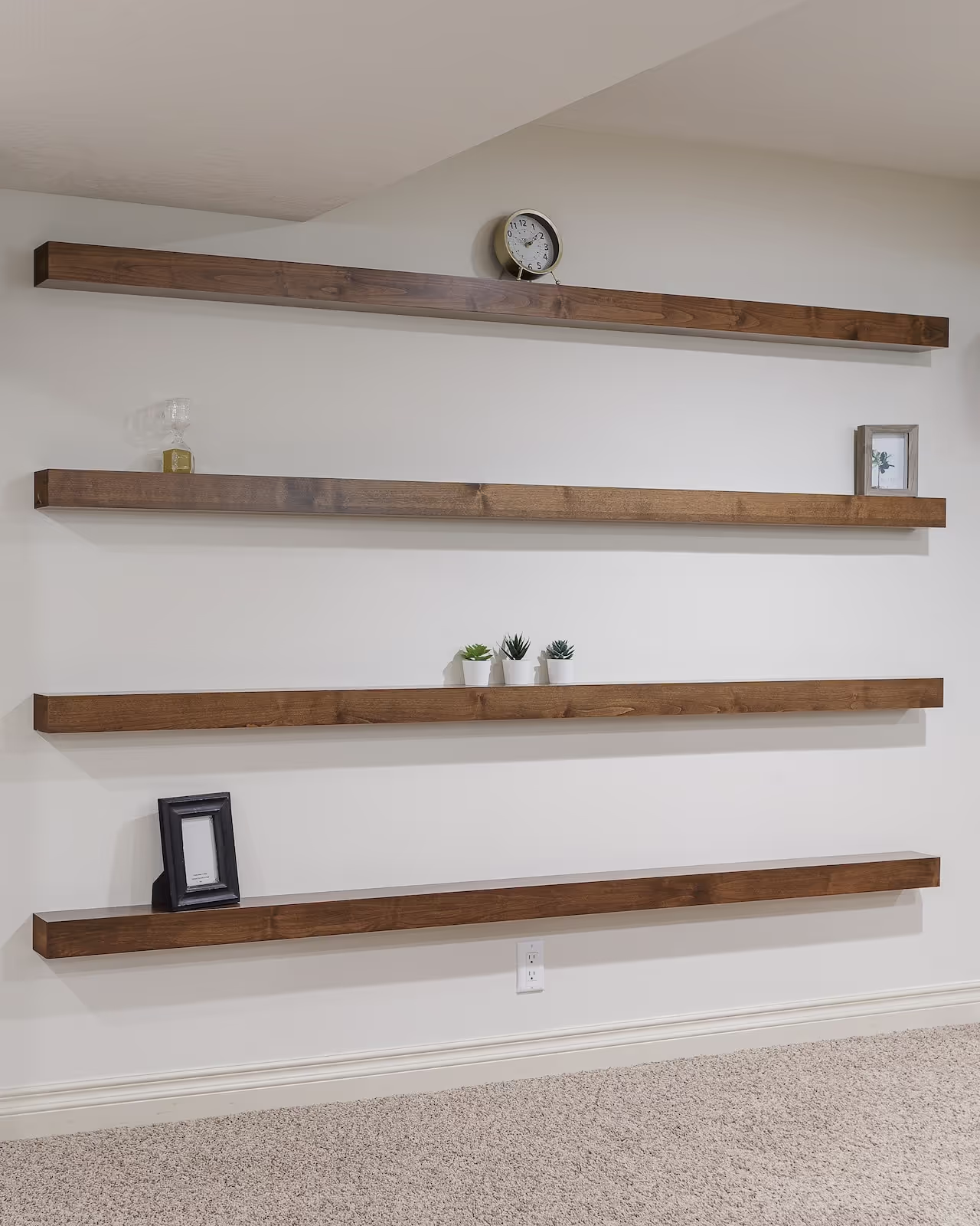 Floating wood shelves with minimalist styling and custom wall cabinetry in a modern living space. Cabinetry by Marvel Cabinetry.