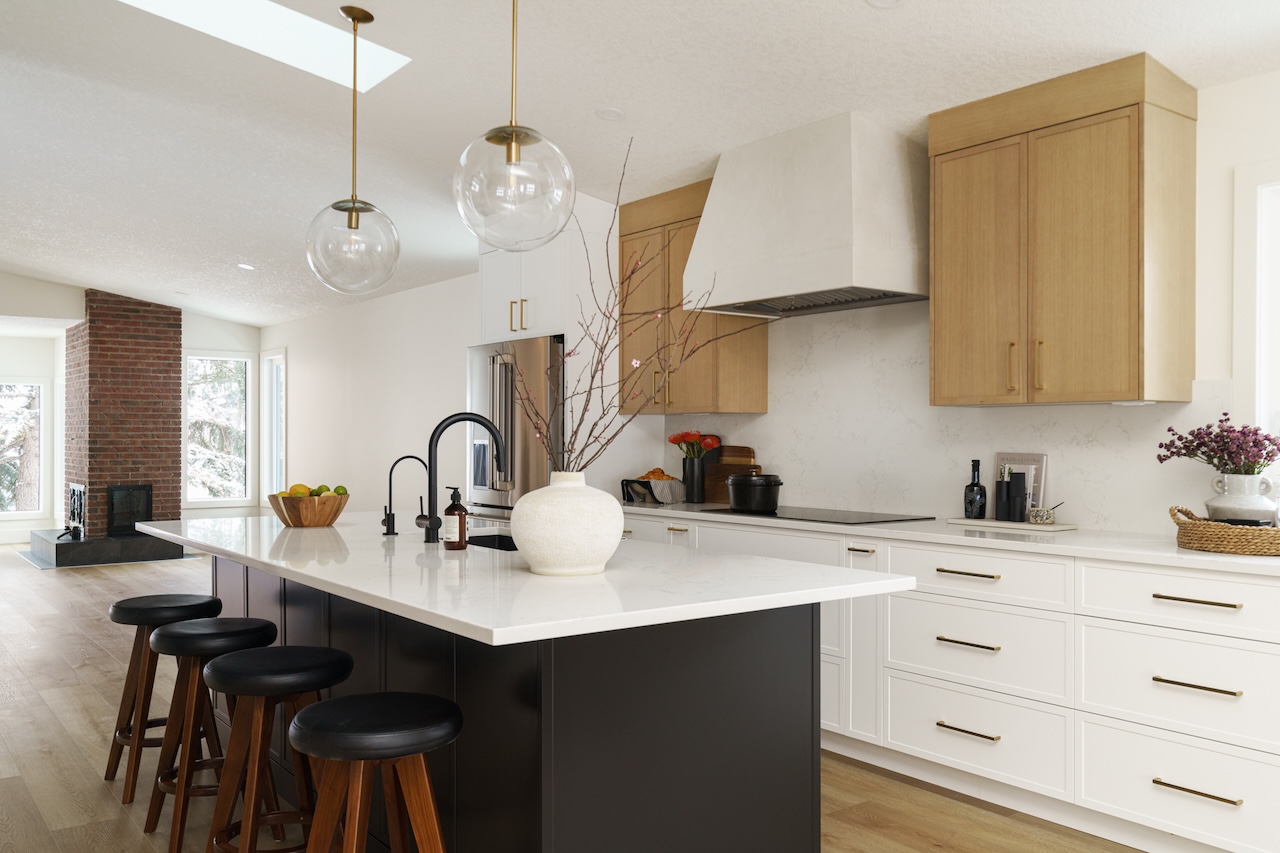 White and wood kitchen with large island, pendant lights, and high-end custom cabinetry throughout. Cabinetry by Marvel Cabinetry.