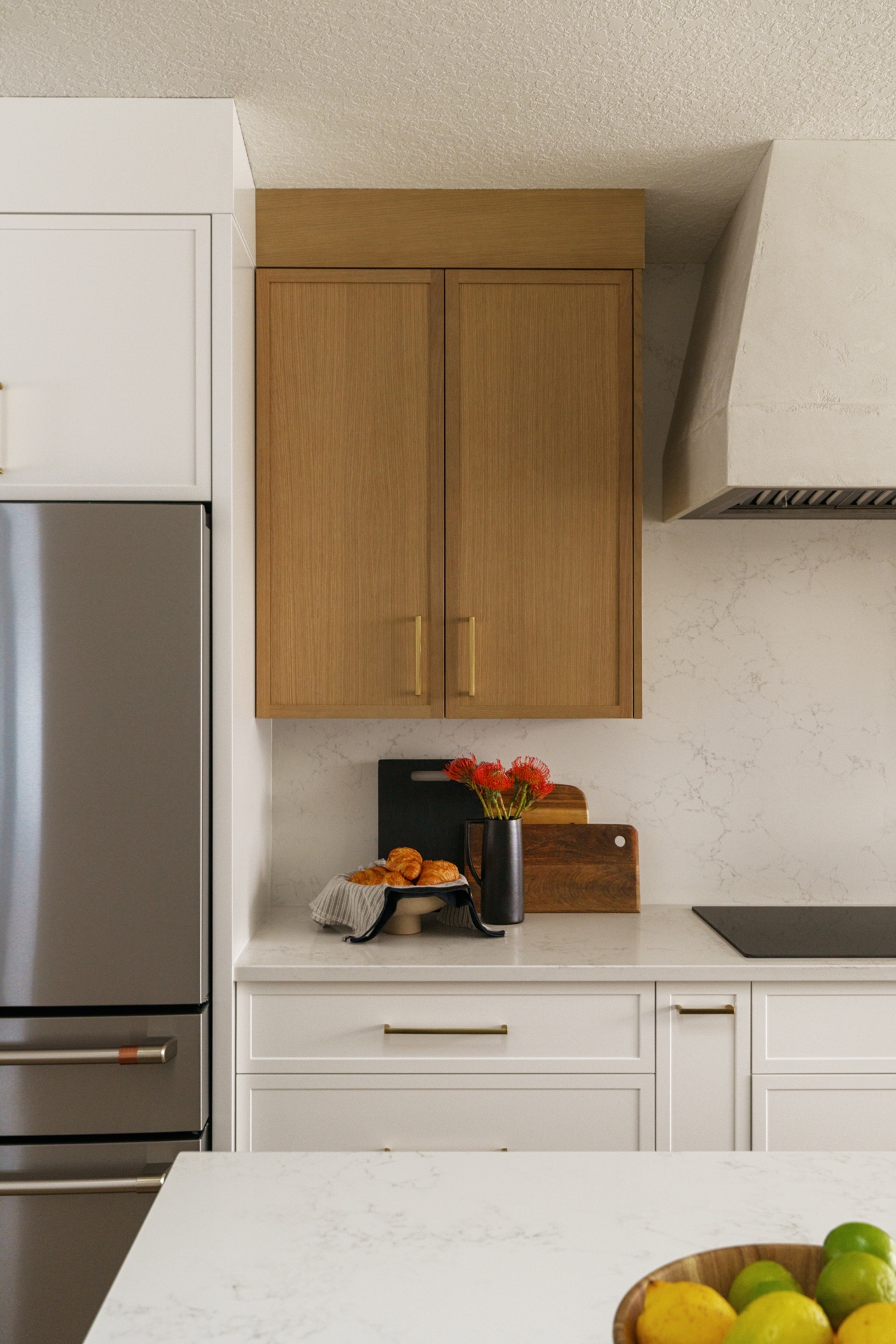 Close-up of custom wood upper cabinets beside stainless-steel appliances in a modern kitchen. Cabinetry by Marvel Cabinetry.