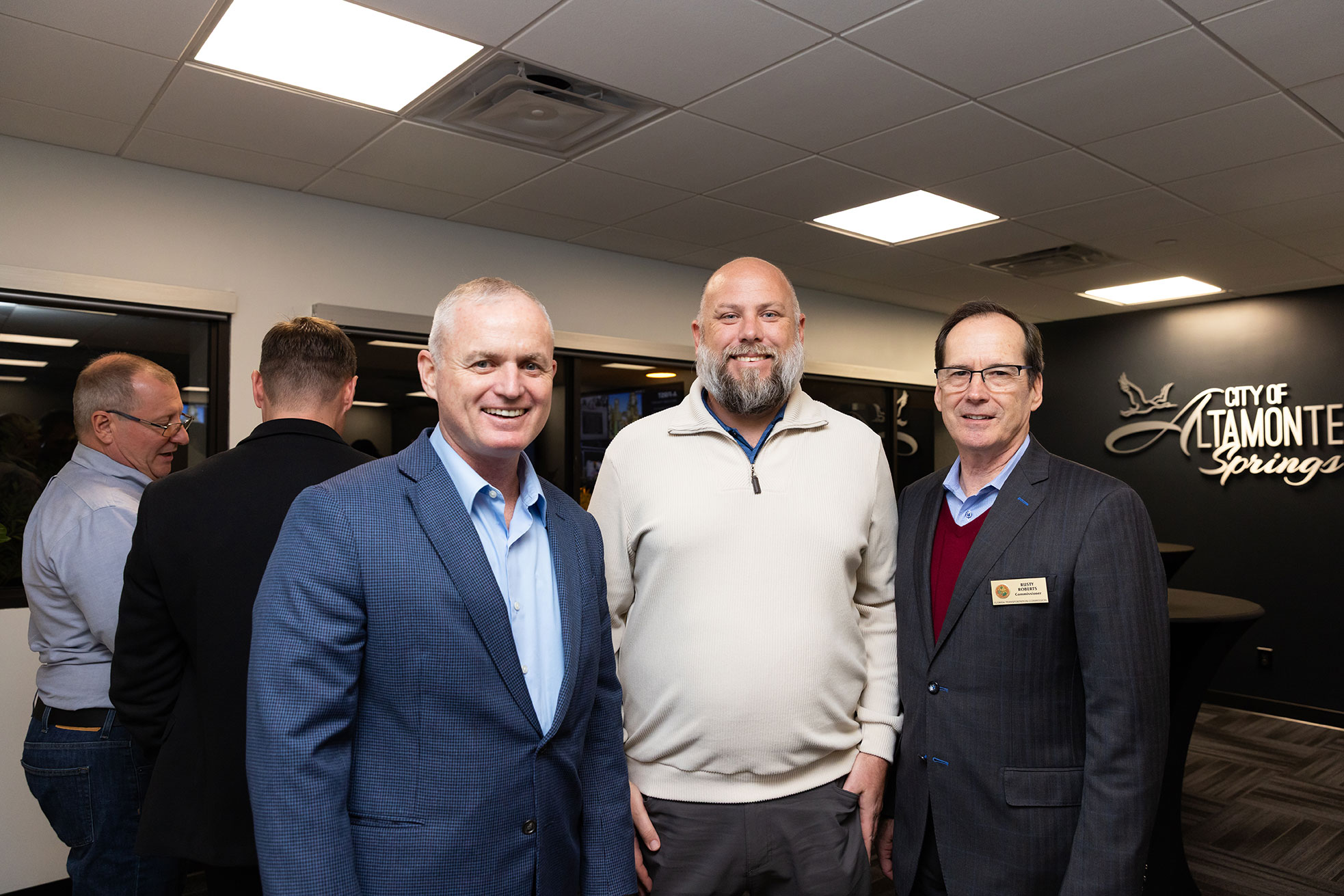 Three male event guests smiling at the camera
