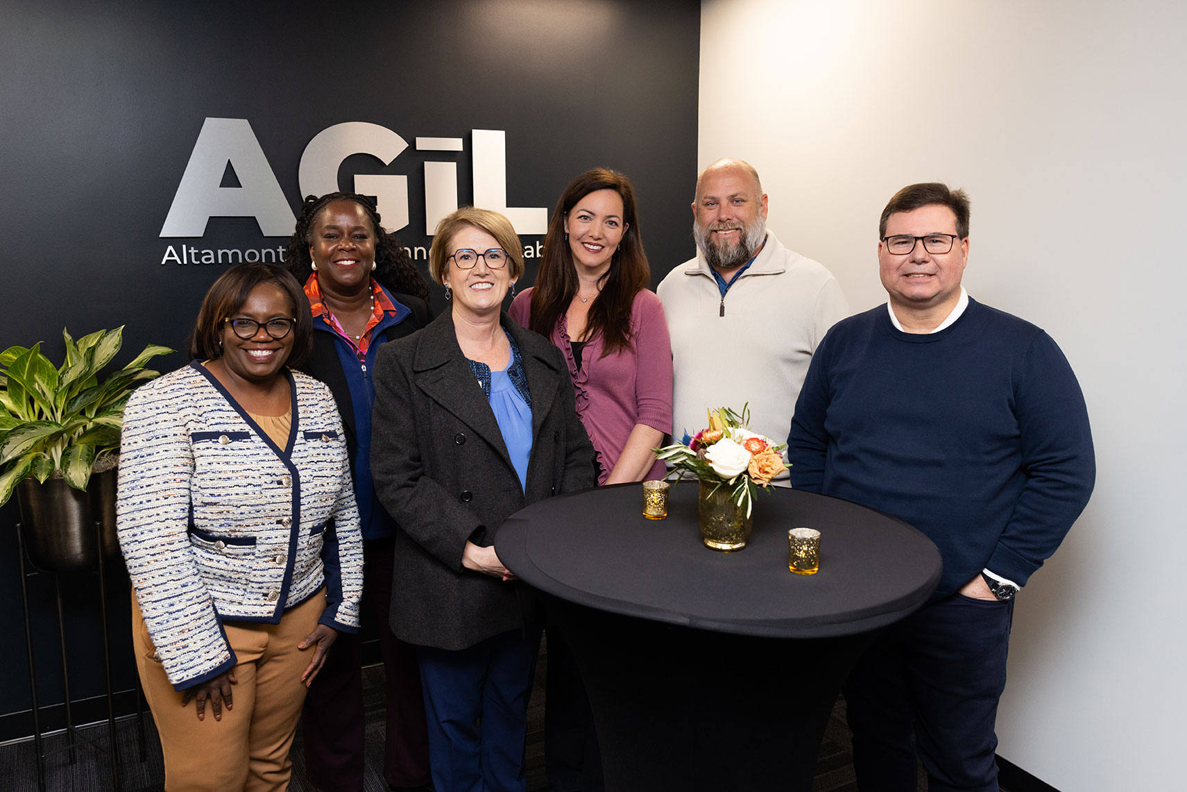 Event guests grouped in front of the AGiL logo wall