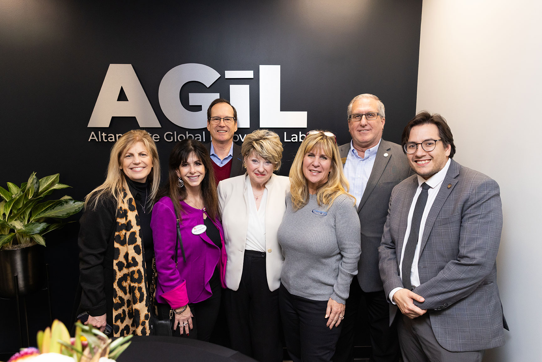 Event guests grouped in front of the AGiL logo wall