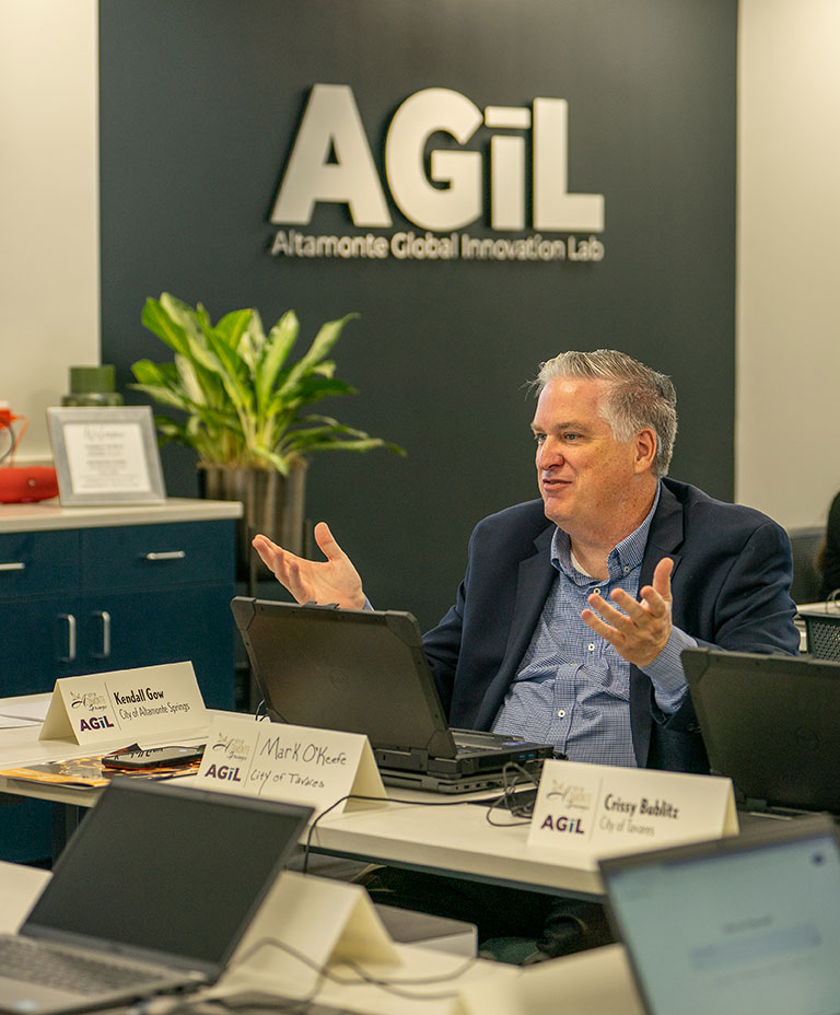 Man sitting at a computer and making a comment during the presentation