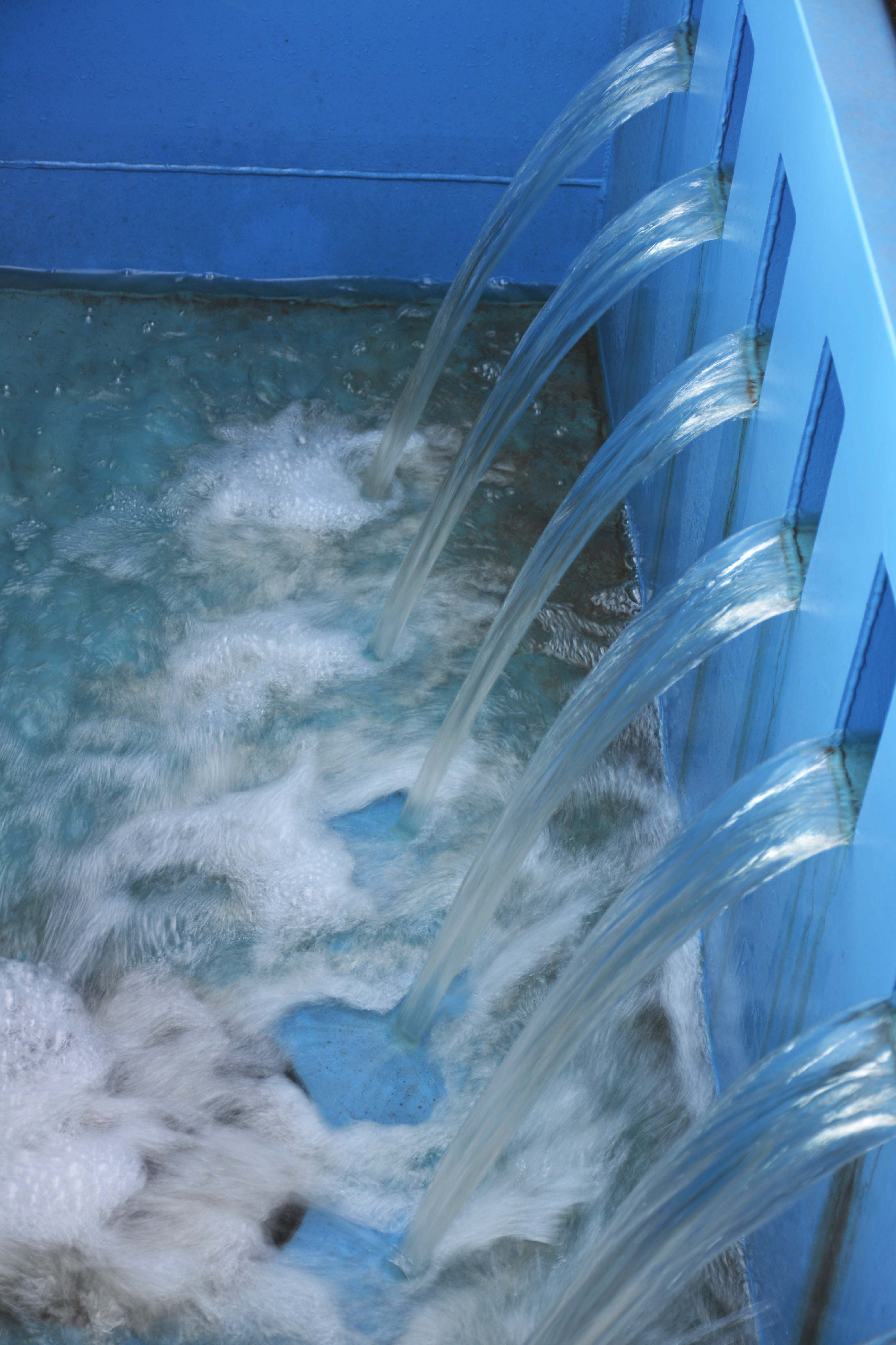 Reclaimed water pouring filtering through holes into a pool below