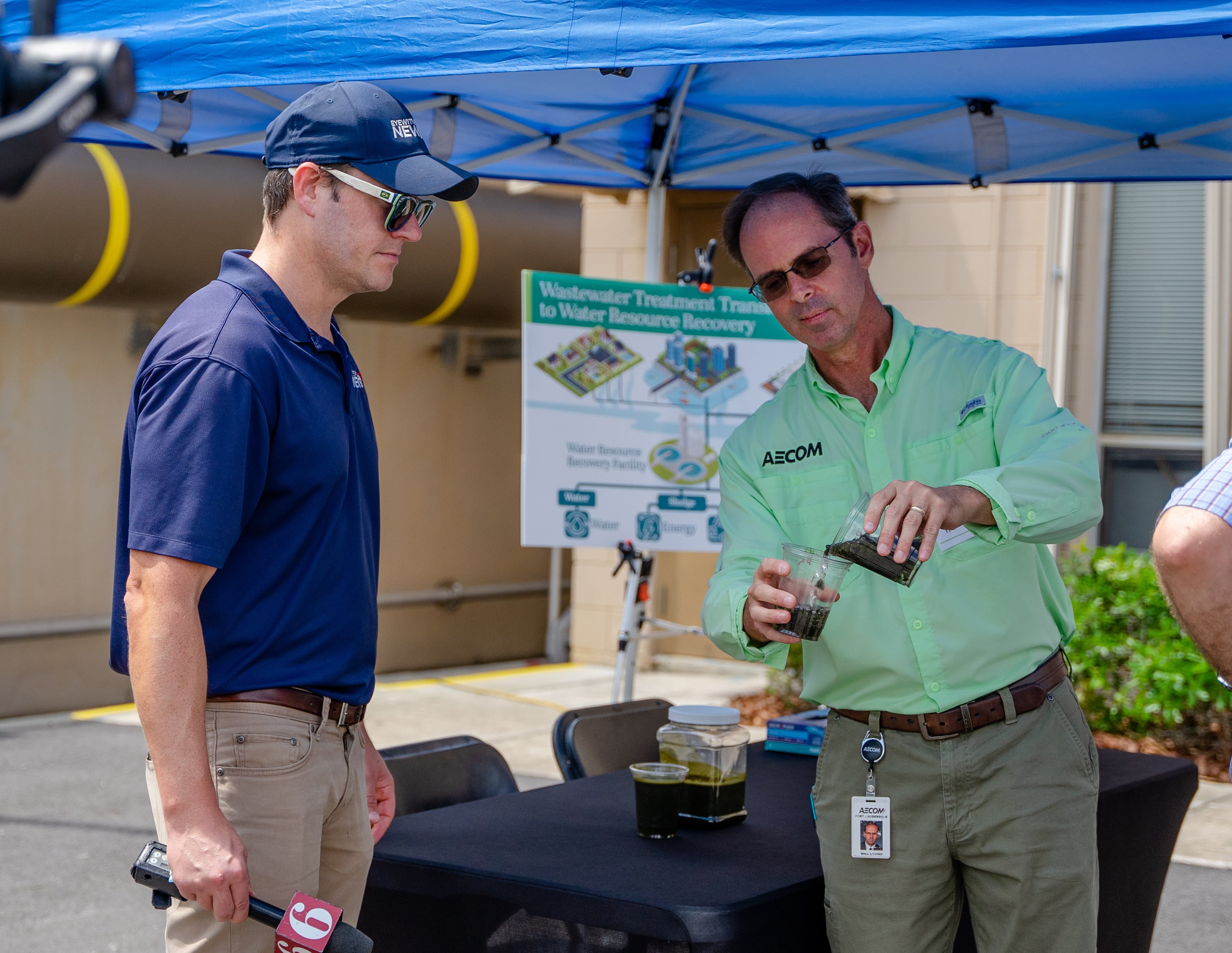Man pours sludge into a cup while another man watches