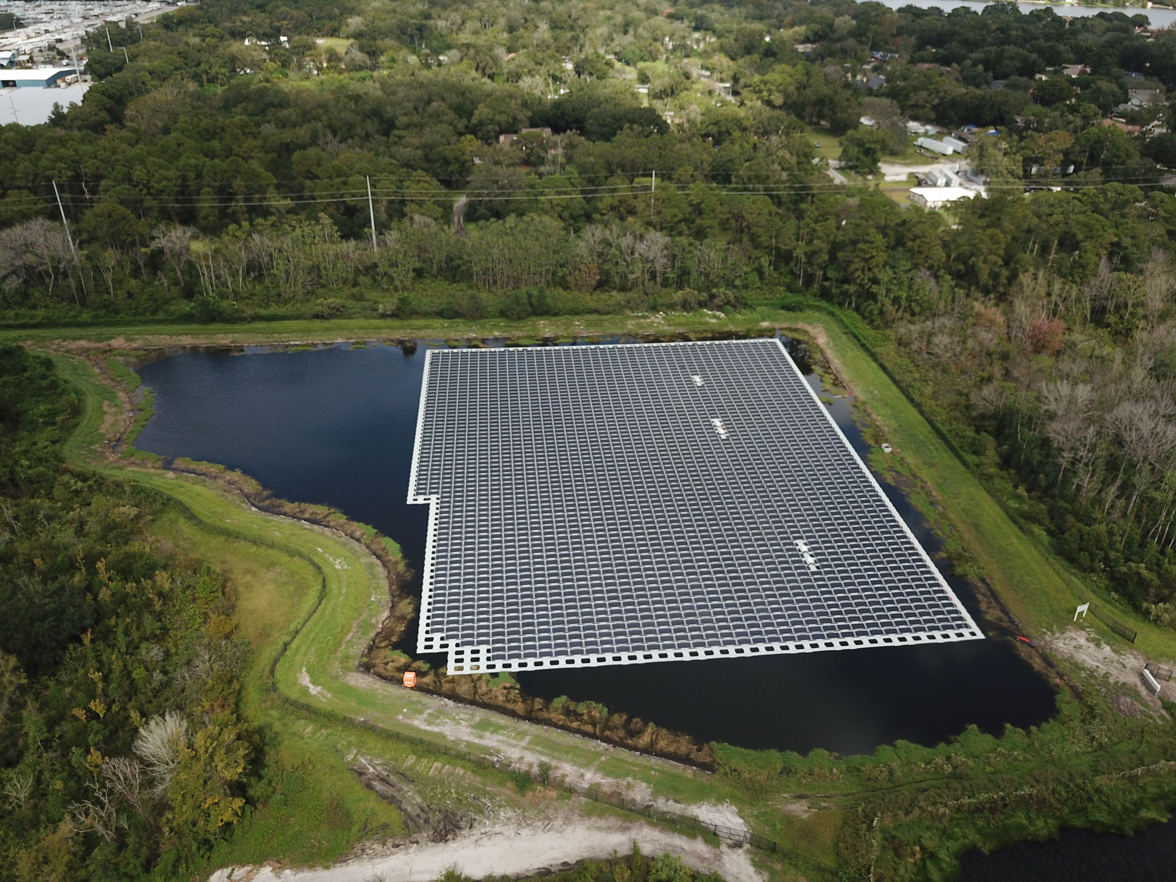 Aerial view of a pond with solar panels