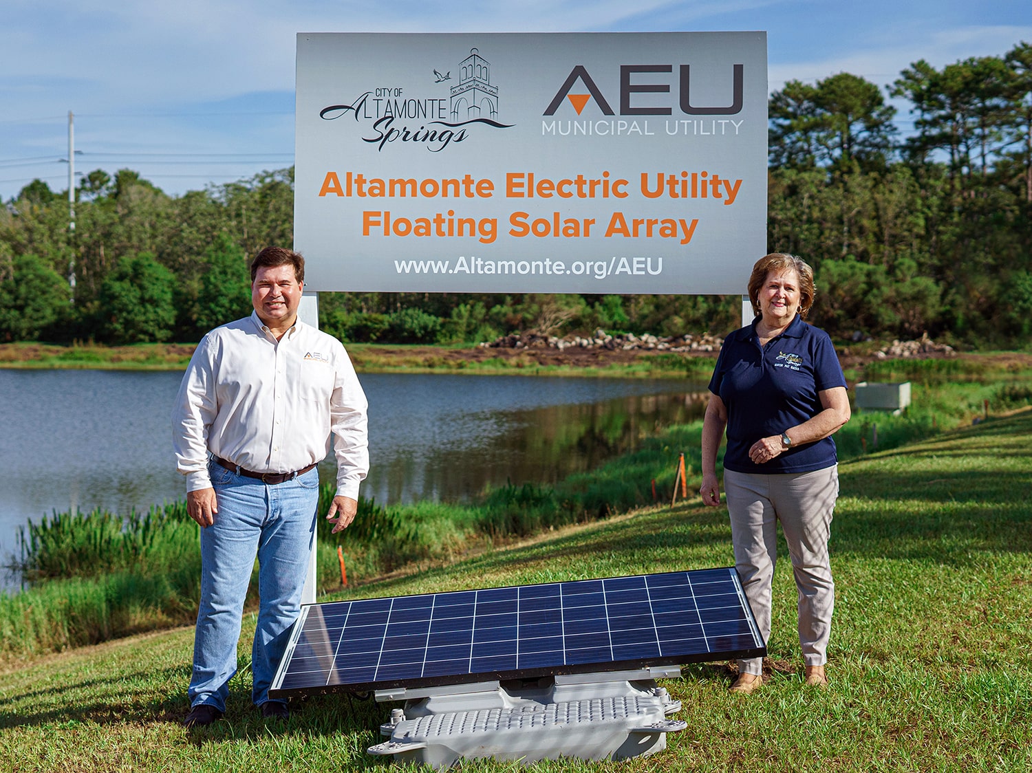 City officials standing next to the AEU project sign