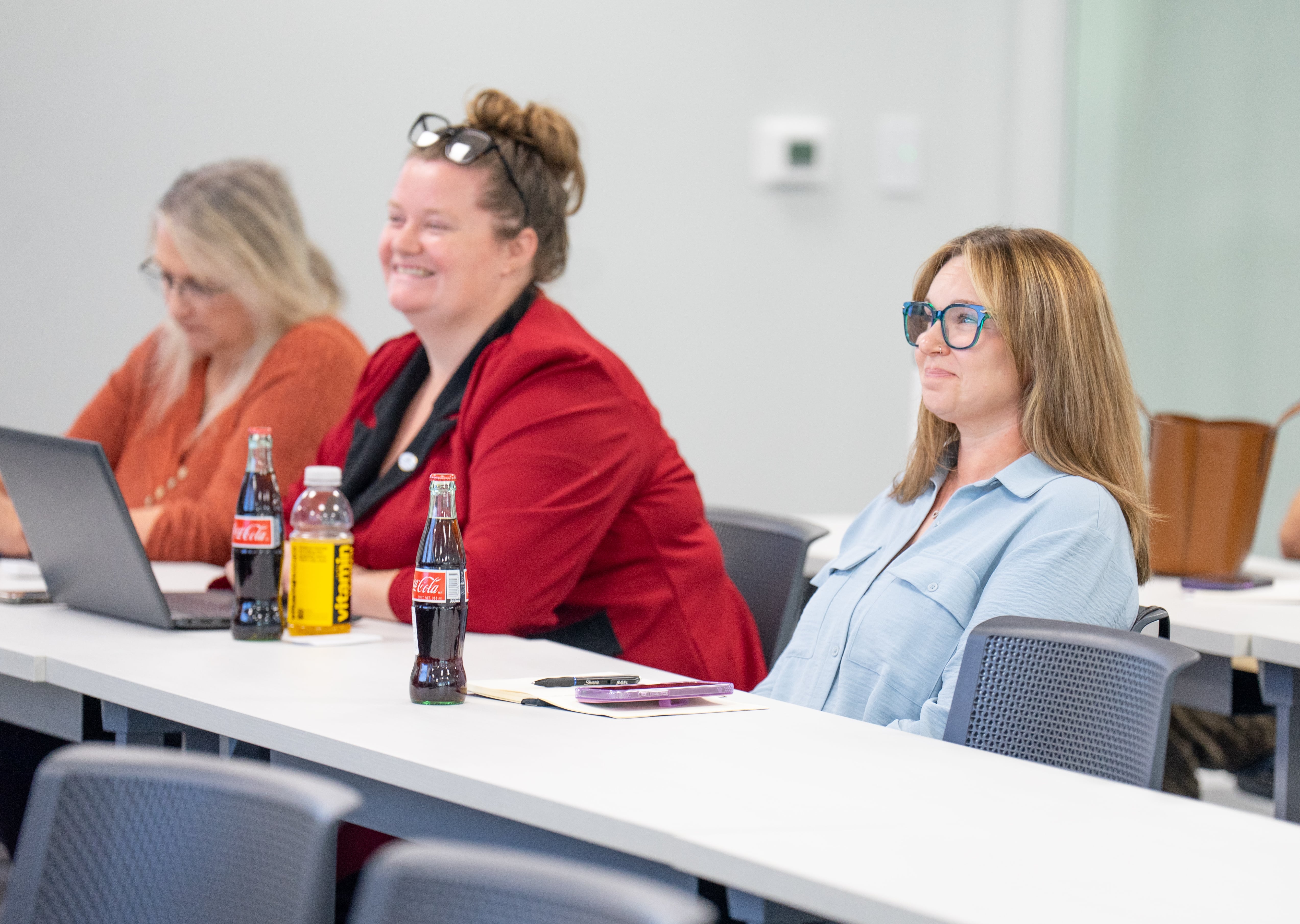 Women sitting at a table listening to a lecture