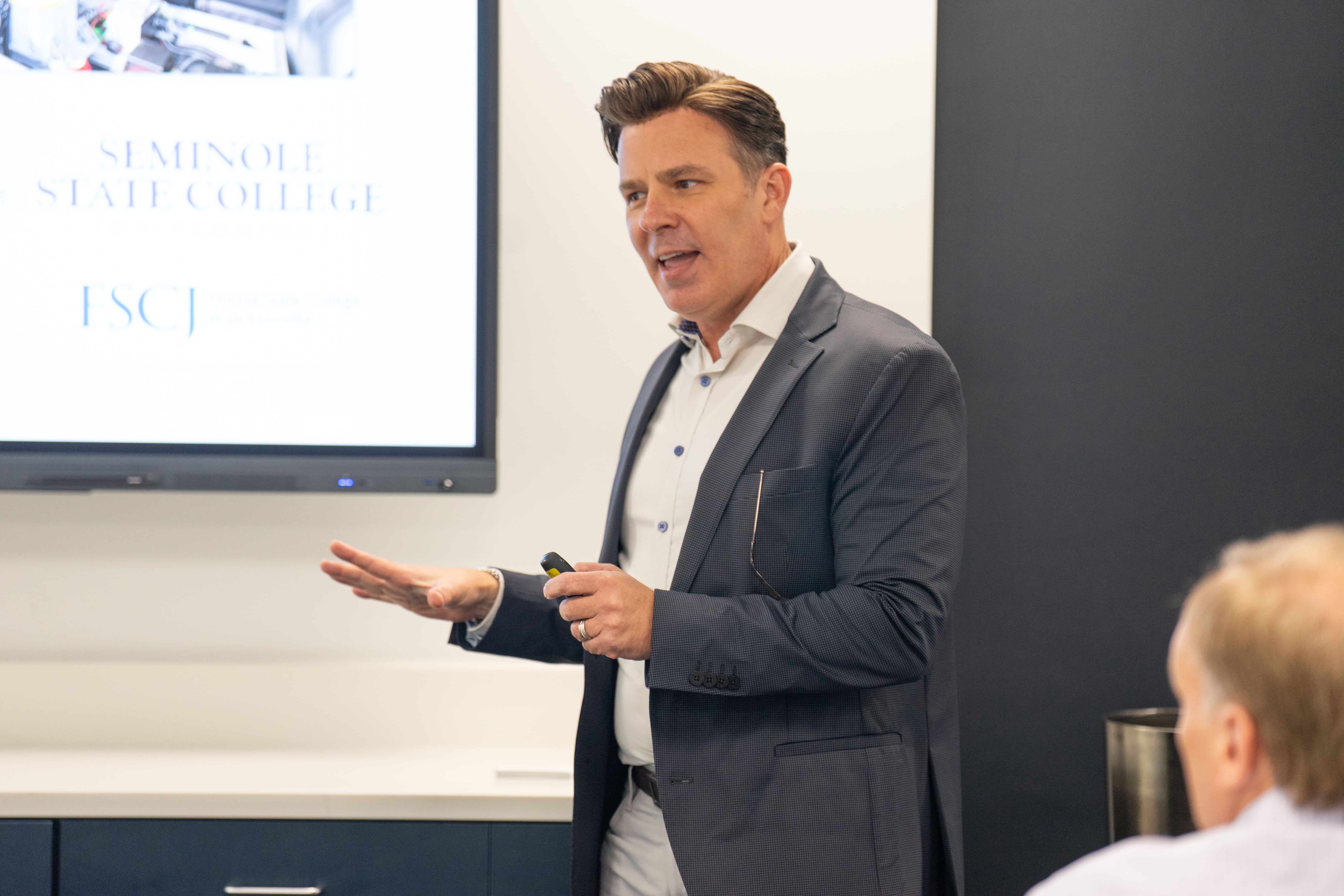 Man standing in front of a room presenting a lecture
