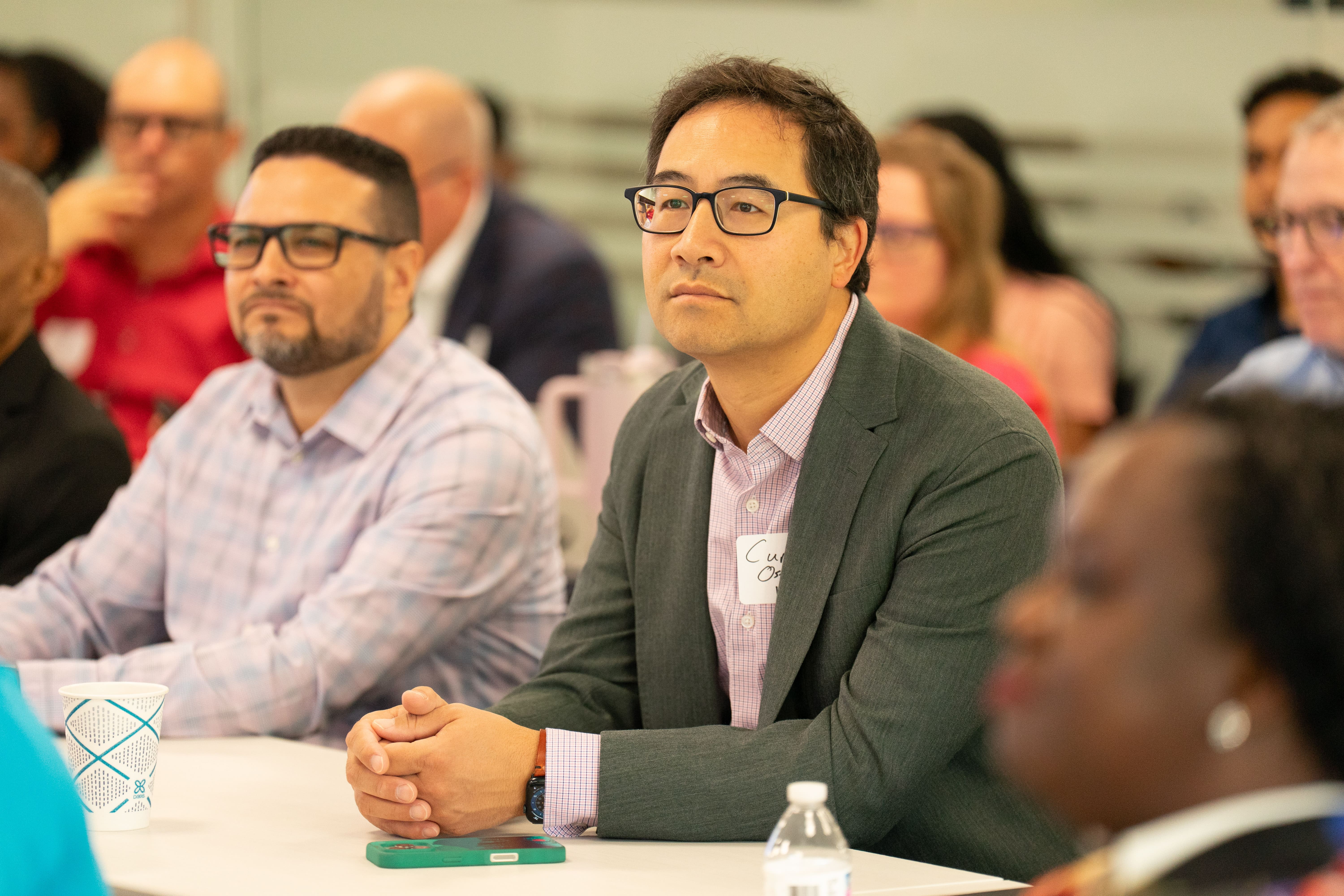 Man in glasses listens intently to the presentation speaker