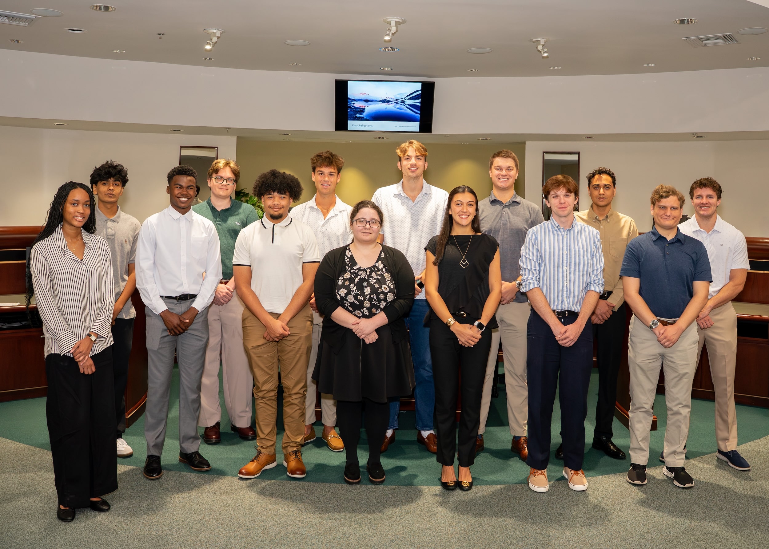 Large diverse group of students smiling at camera in commission chambers