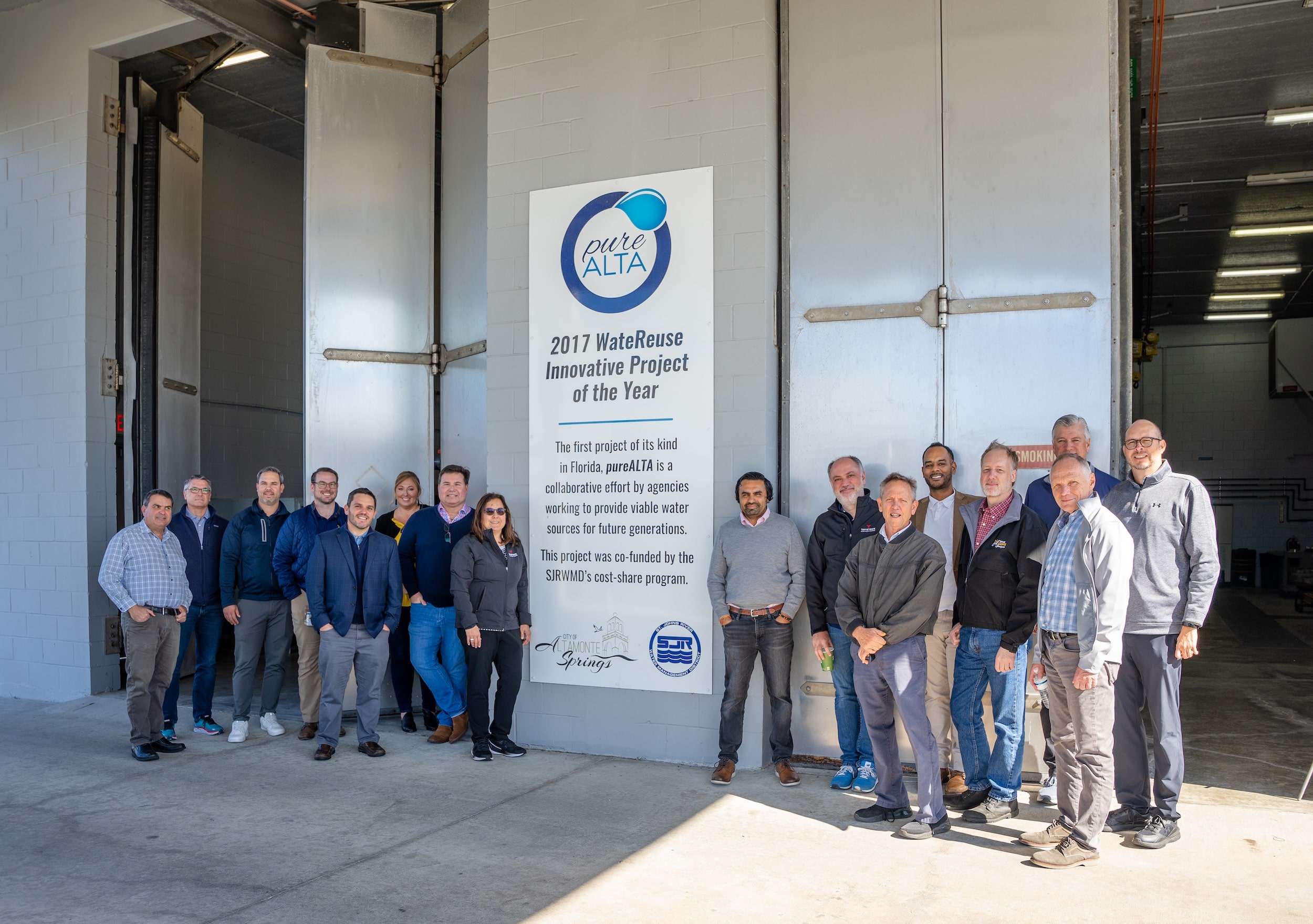 Group of people pose by the pureALTA award sign