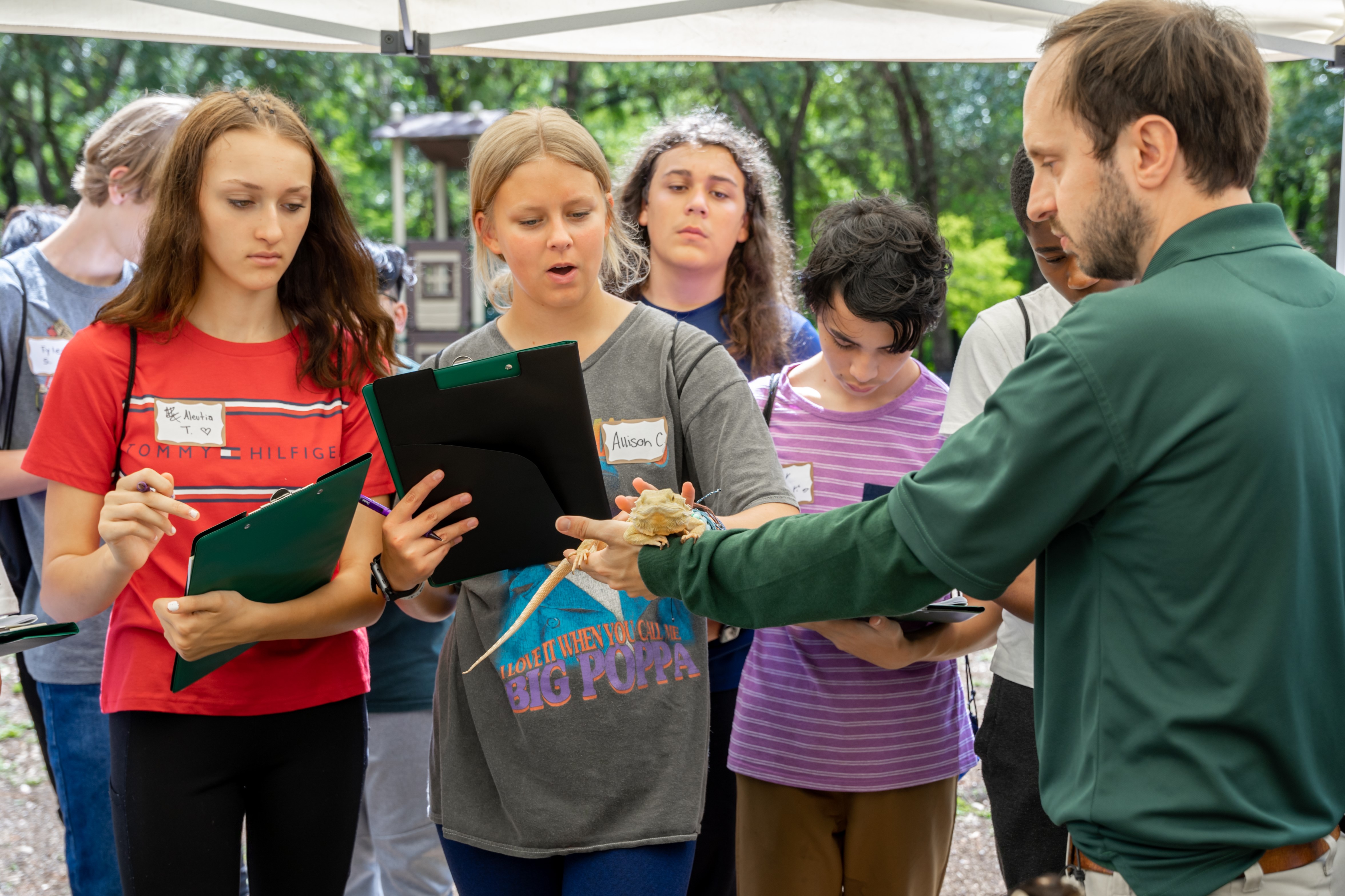 Park ranger holds a lizard for students to view