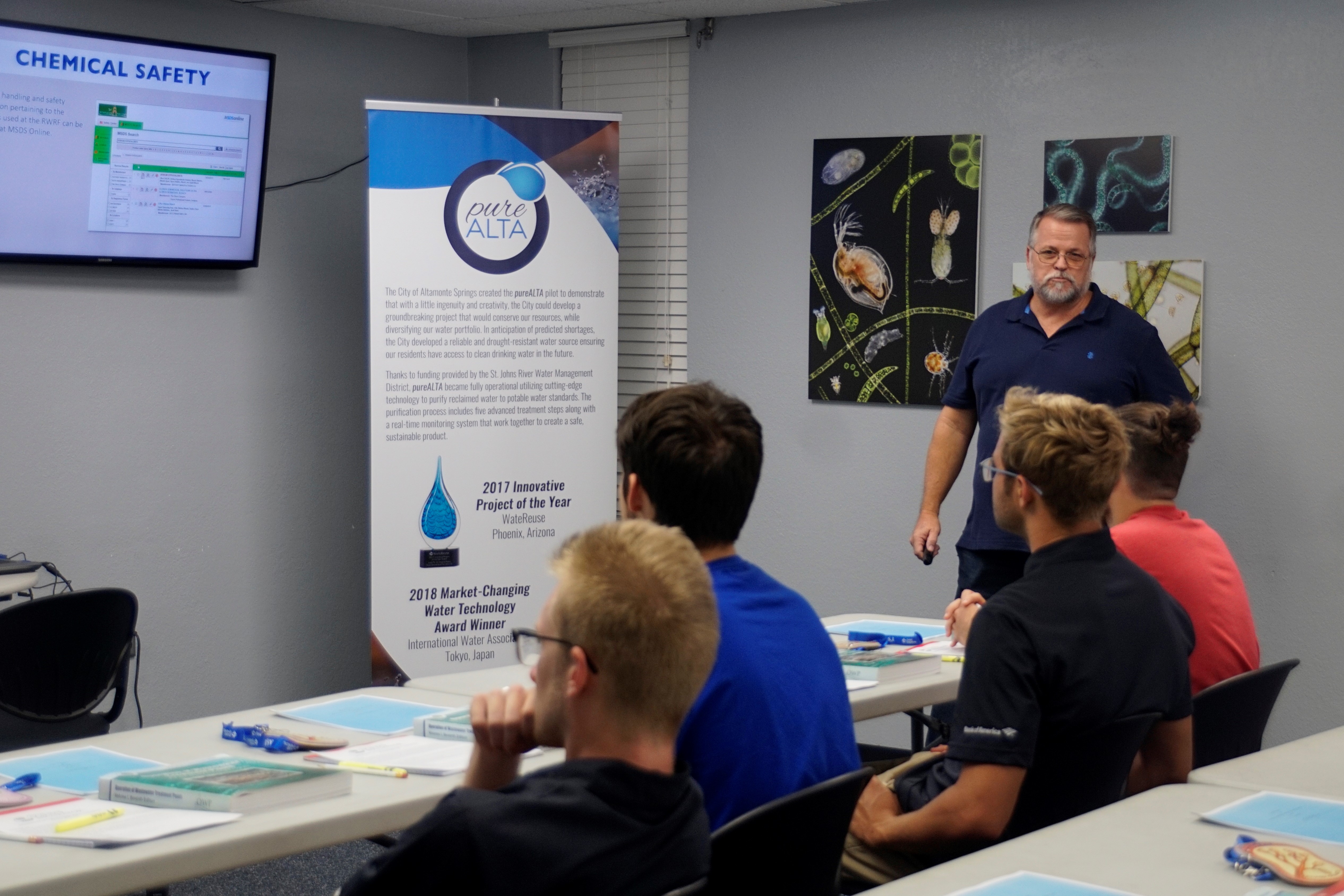 Course instructor presenting to students sitting at a table