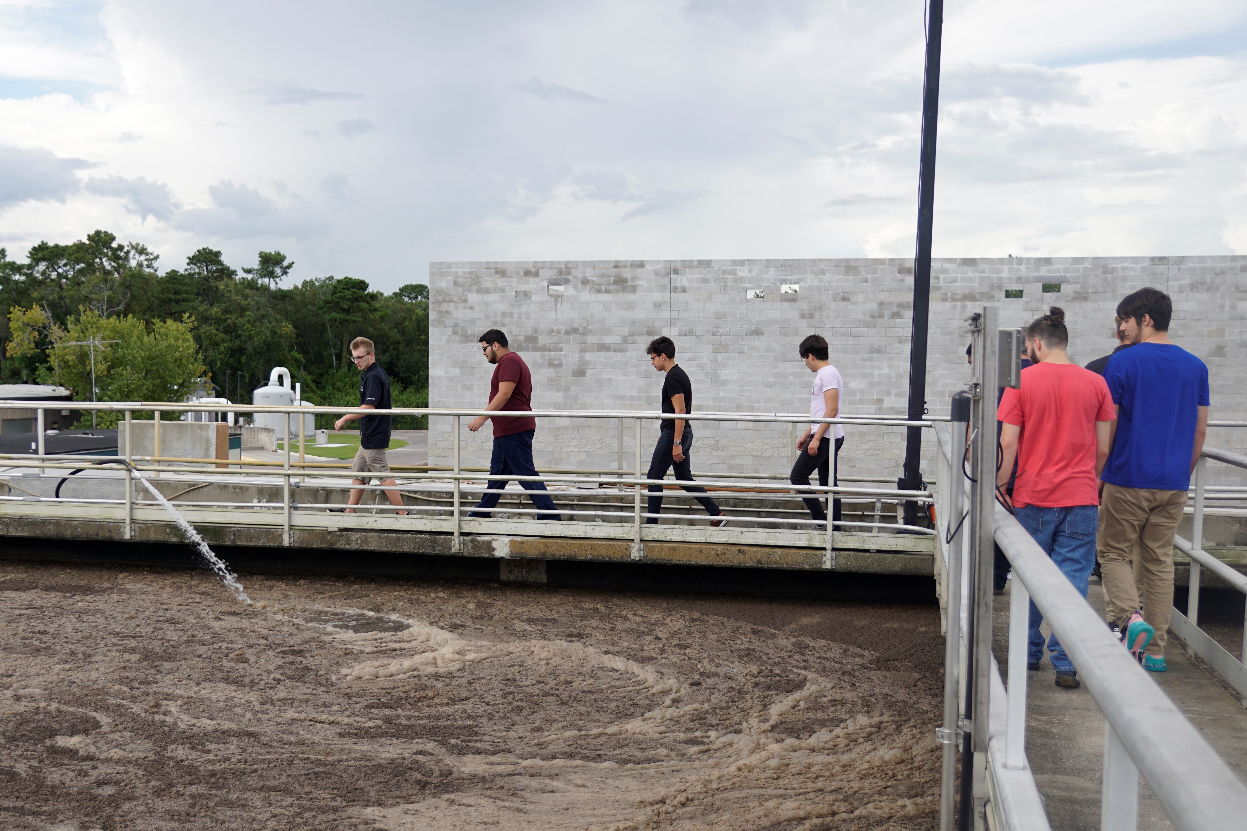 Students walking along the water tank at the water plant