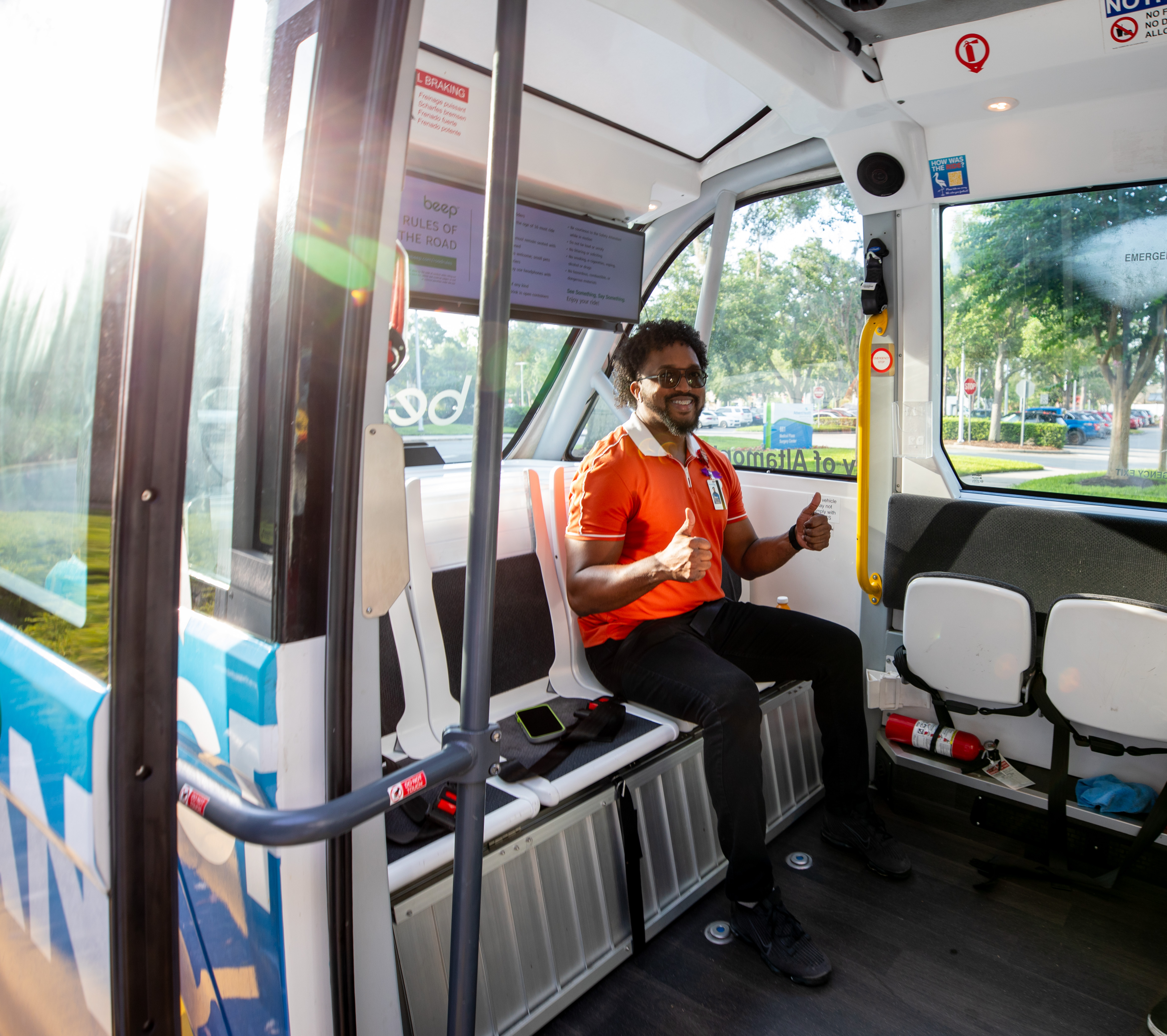 Man giving a thumbs up while sitting in the CraneRIDES shuttle