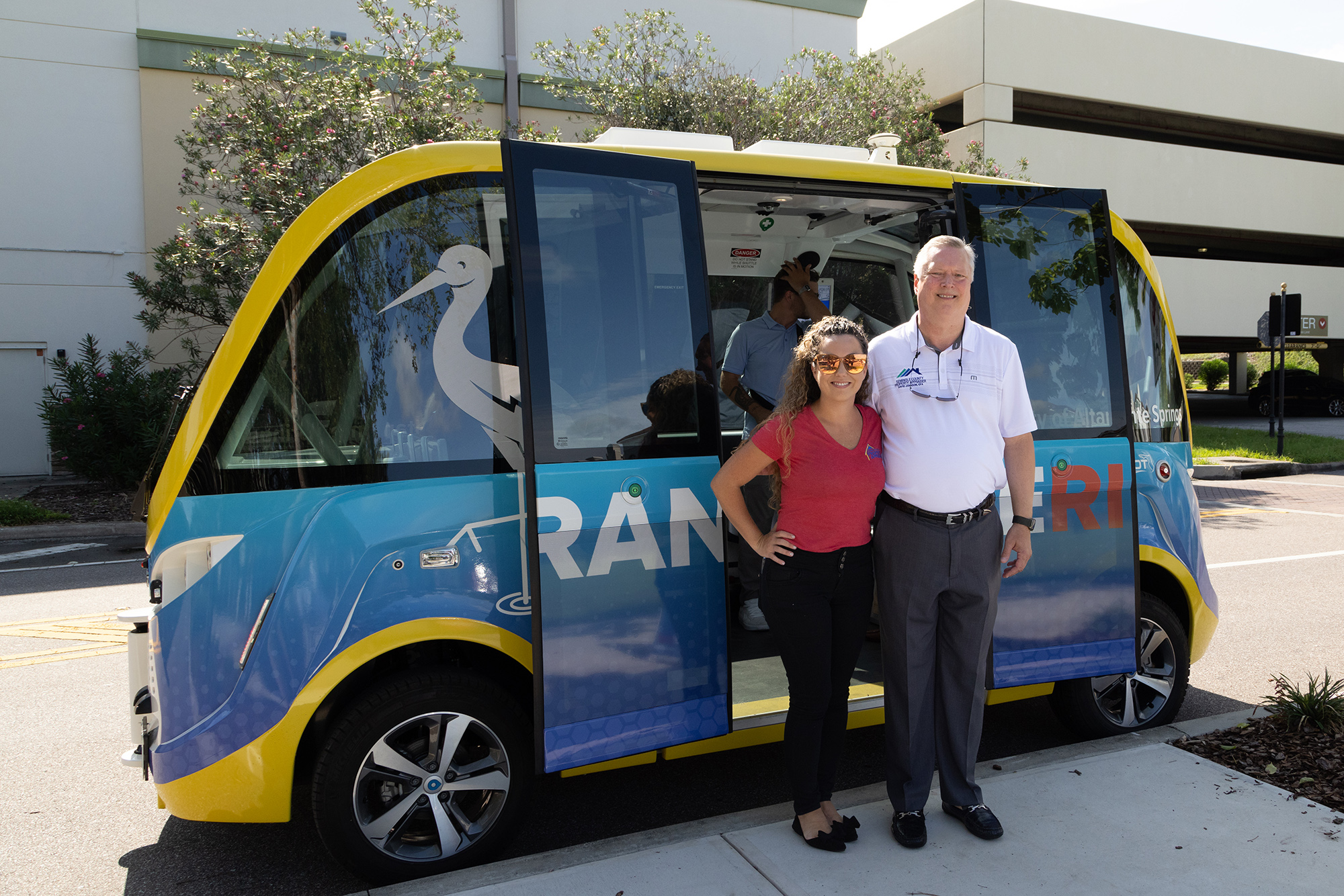 Elected officials pose next to the CraneRIDES shuttle