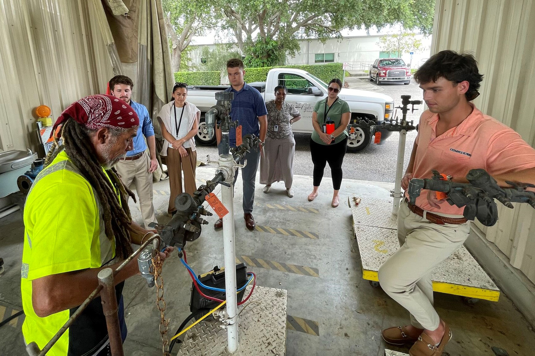FSU Student interns observe a Public Works employee working with machinery