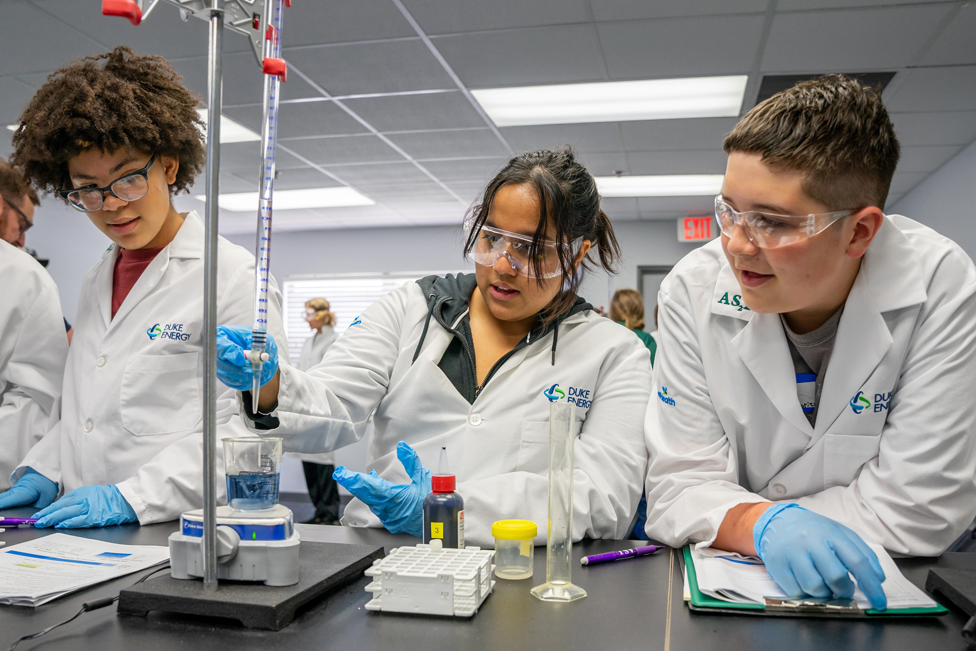 Students wearing lab coats conducting an experiment