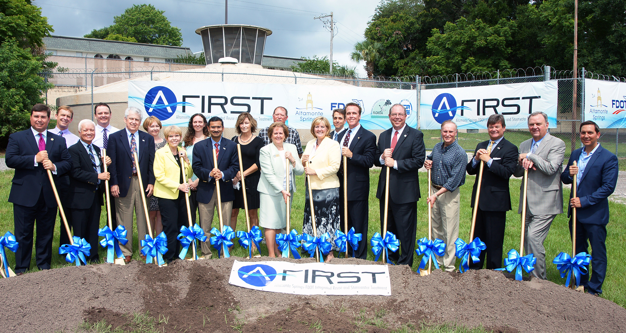 City staff and elected officials pose with gold shovels in the dirt at the A-FIRST ground breaking ceremony