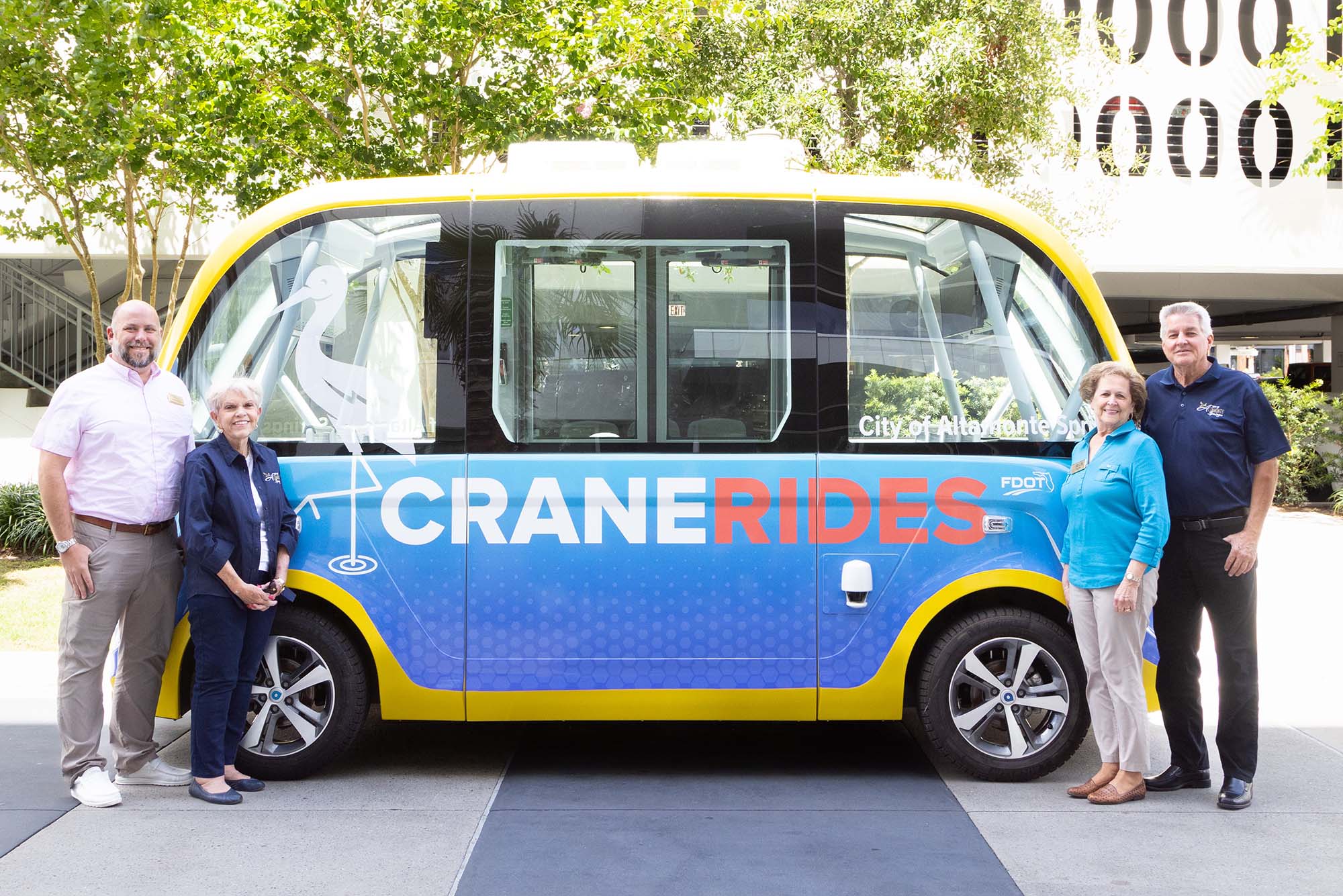 City Commission poses in front of the CraneRIDES shuttle