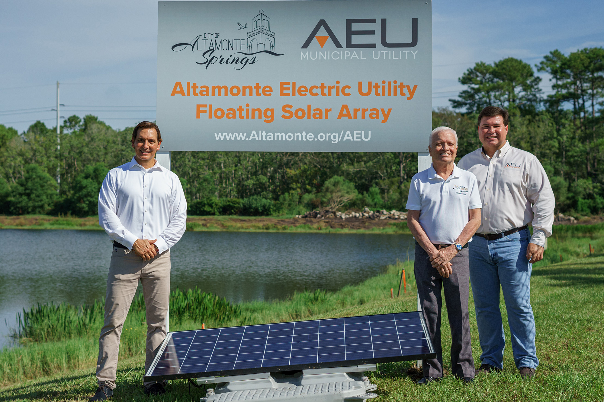 City officials standing next to the AEU project sign