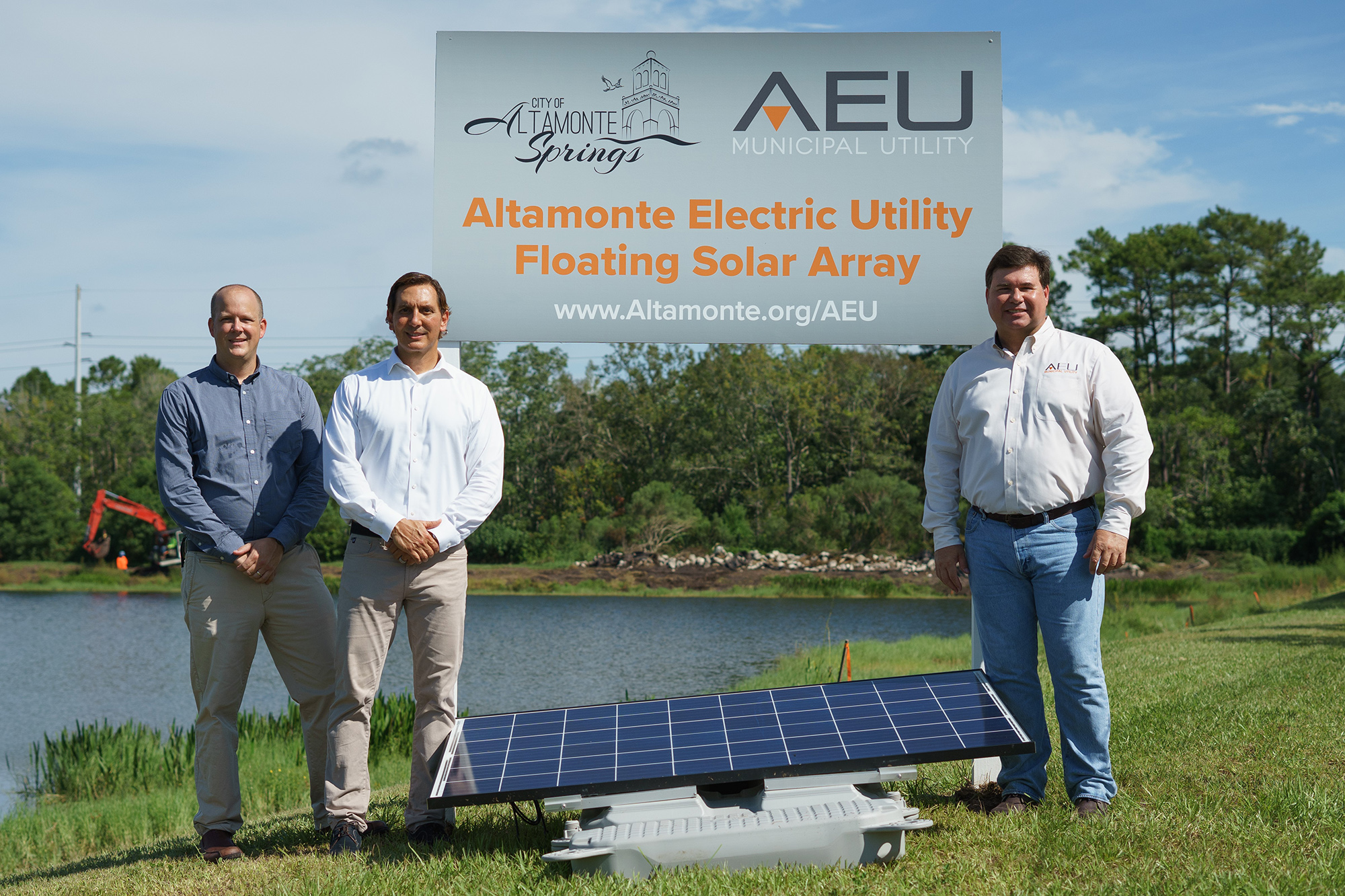 City manager and engineers standing next to the AEU project sign