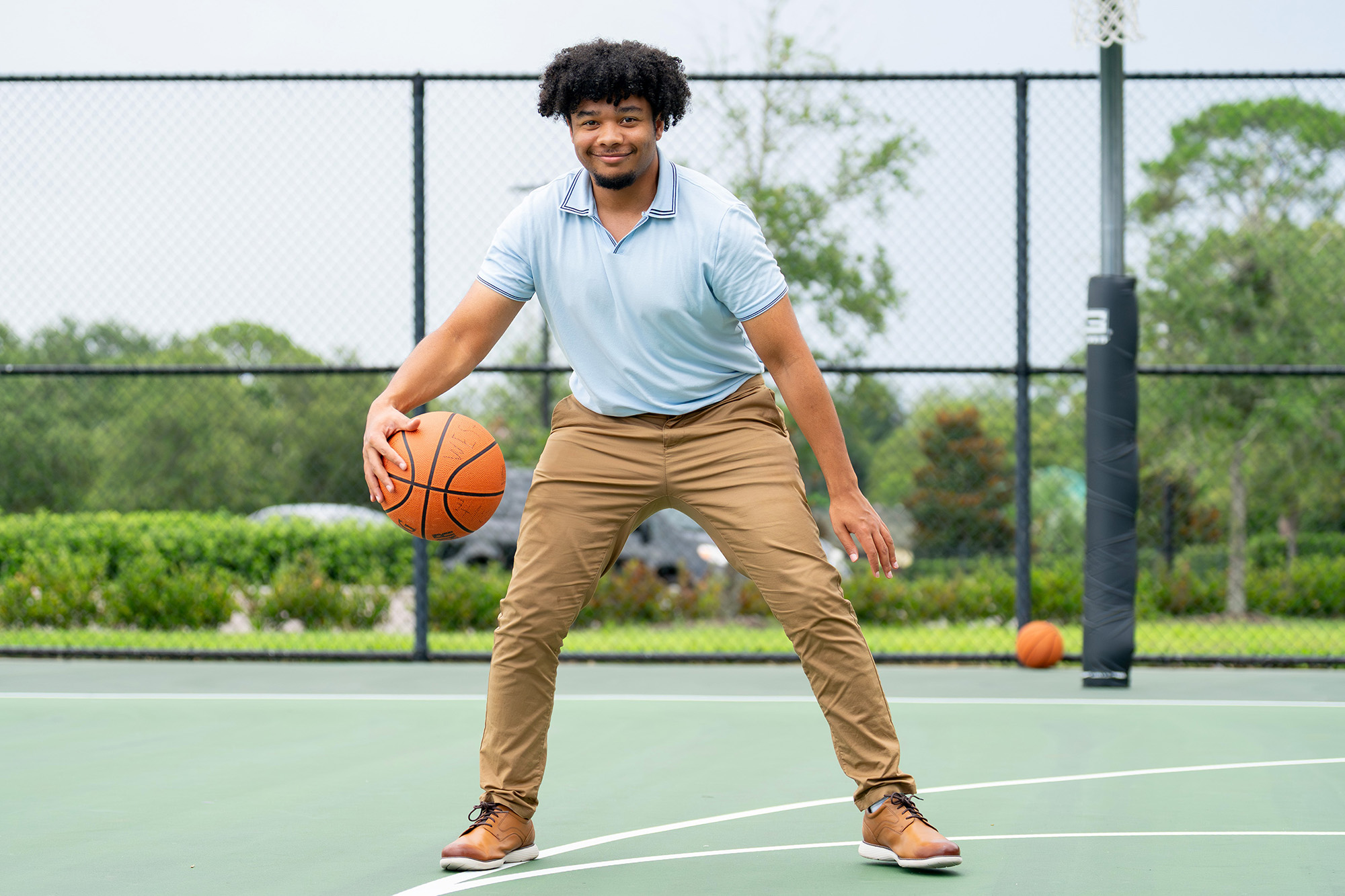 Recreation student intern on the basketball court holding a basketball