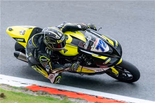 Racing motorcycle leaning into turn with yellow and black color scheme
