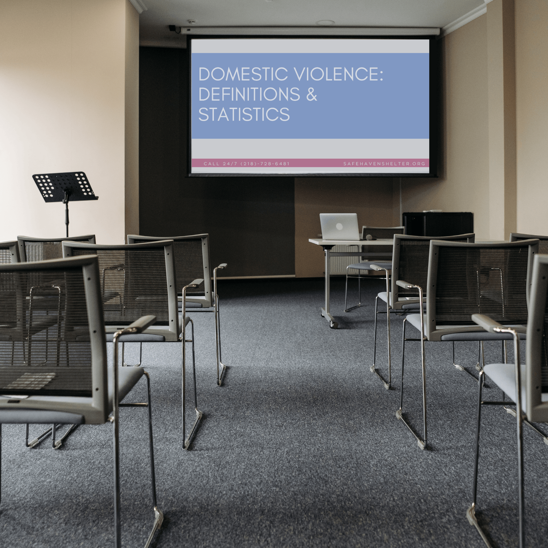 An classroom with a domestic violence powerpoint on the screen in the front of the room.