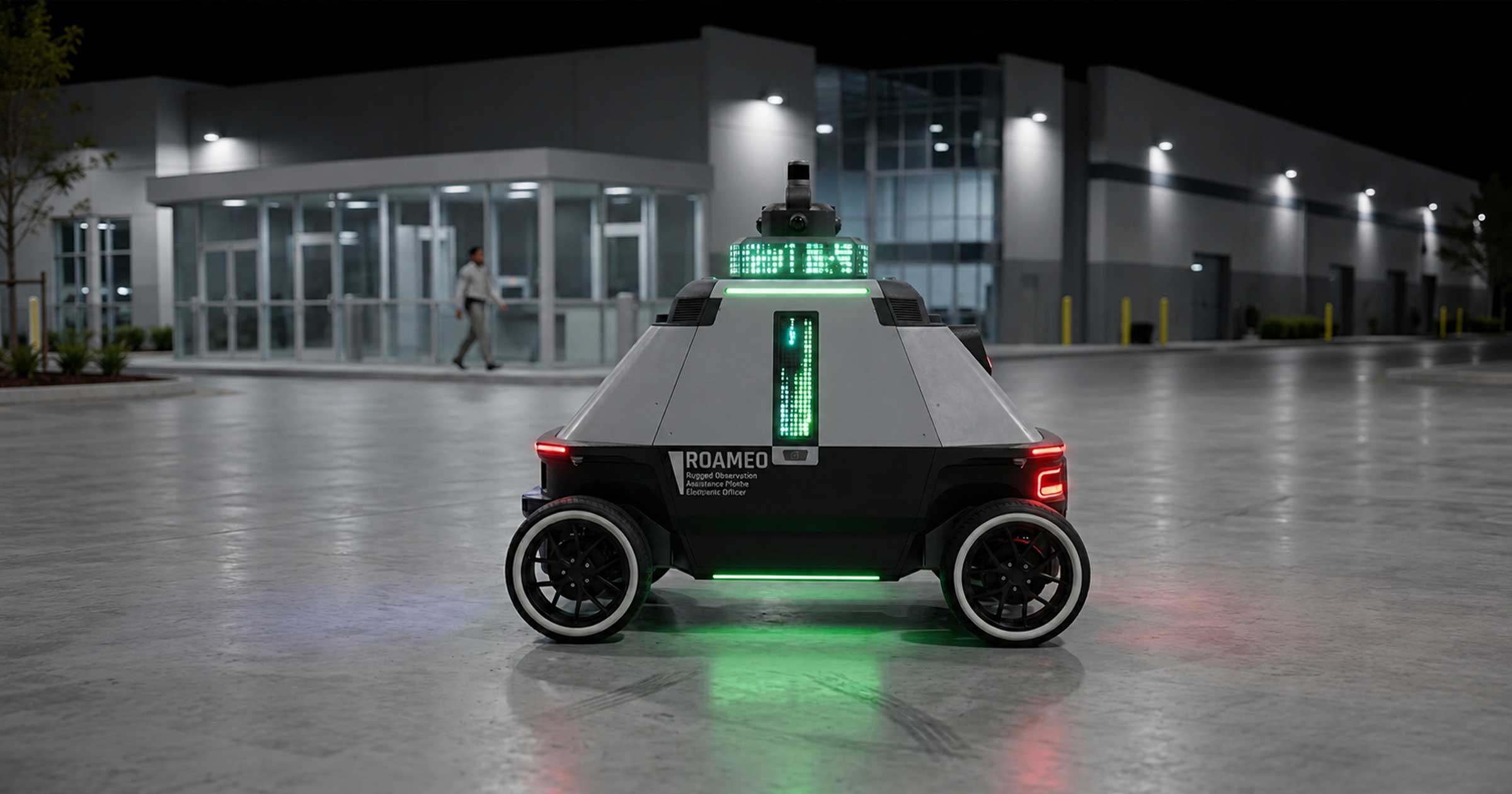 Black and white ROAMEO security robot with green lights parked outside a modern building at night.