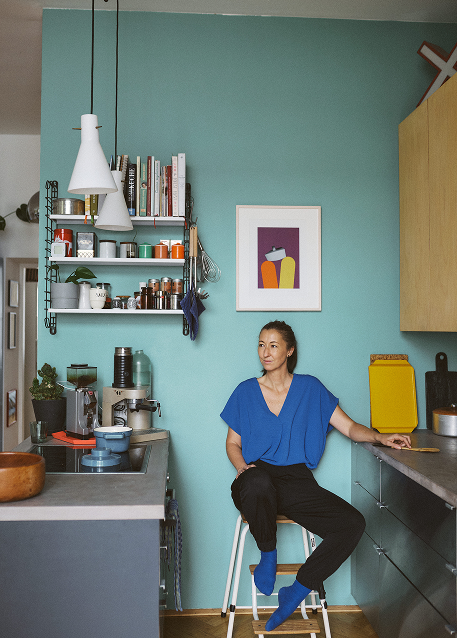 Foto von Lisa Posch in ihrer Küche, sitzend auf einem Barhocker.