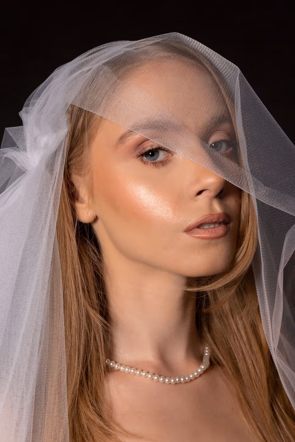 Mlada sa prirodnim bridal makeup lookom, naglašenim tenom i bisernom ogrlicom ispod vela – elegantna venčana šminka u izvedbi Sare Ivanović, profesionalnog šminkera iz Pančeva.