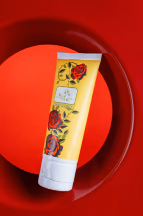 Floral body lotion tube on a red plate with red background, product photography by Photos by Lars.